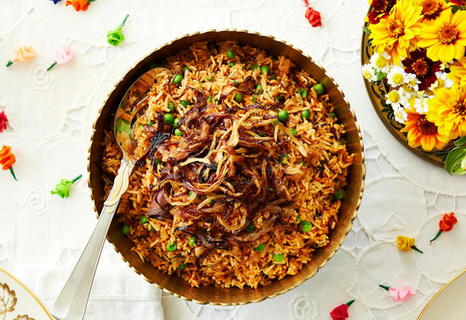 Harissa topped with crunchy burnt onions, fresh flowers, colorful paper roses.