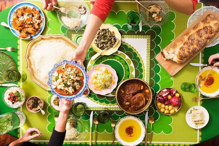 Sukkot dinner spread with fava bean soup, salads, and challah.