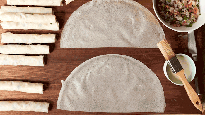 Chef filling and rolling Moroccan fish cigars to be fried.