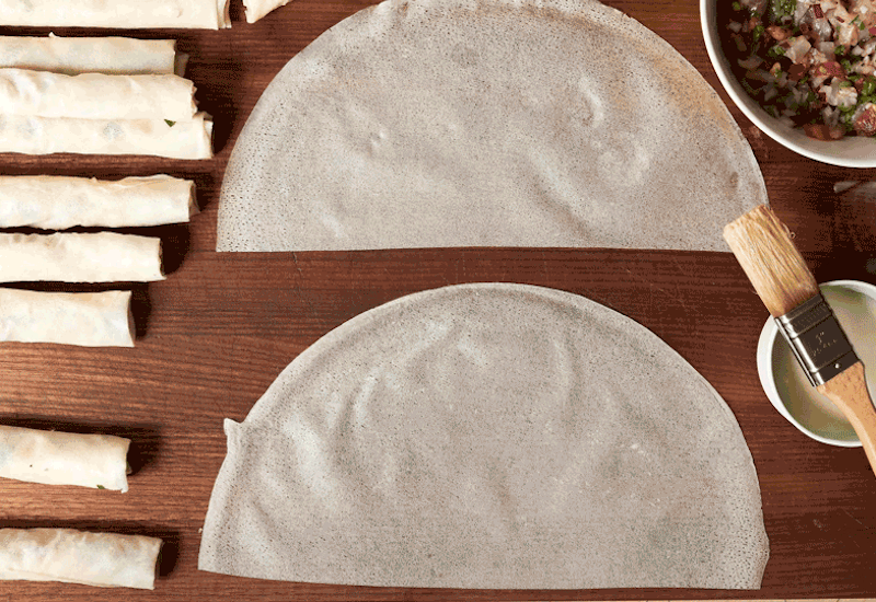 Chef filling and rolling Moroccan fish cigars to be fried.