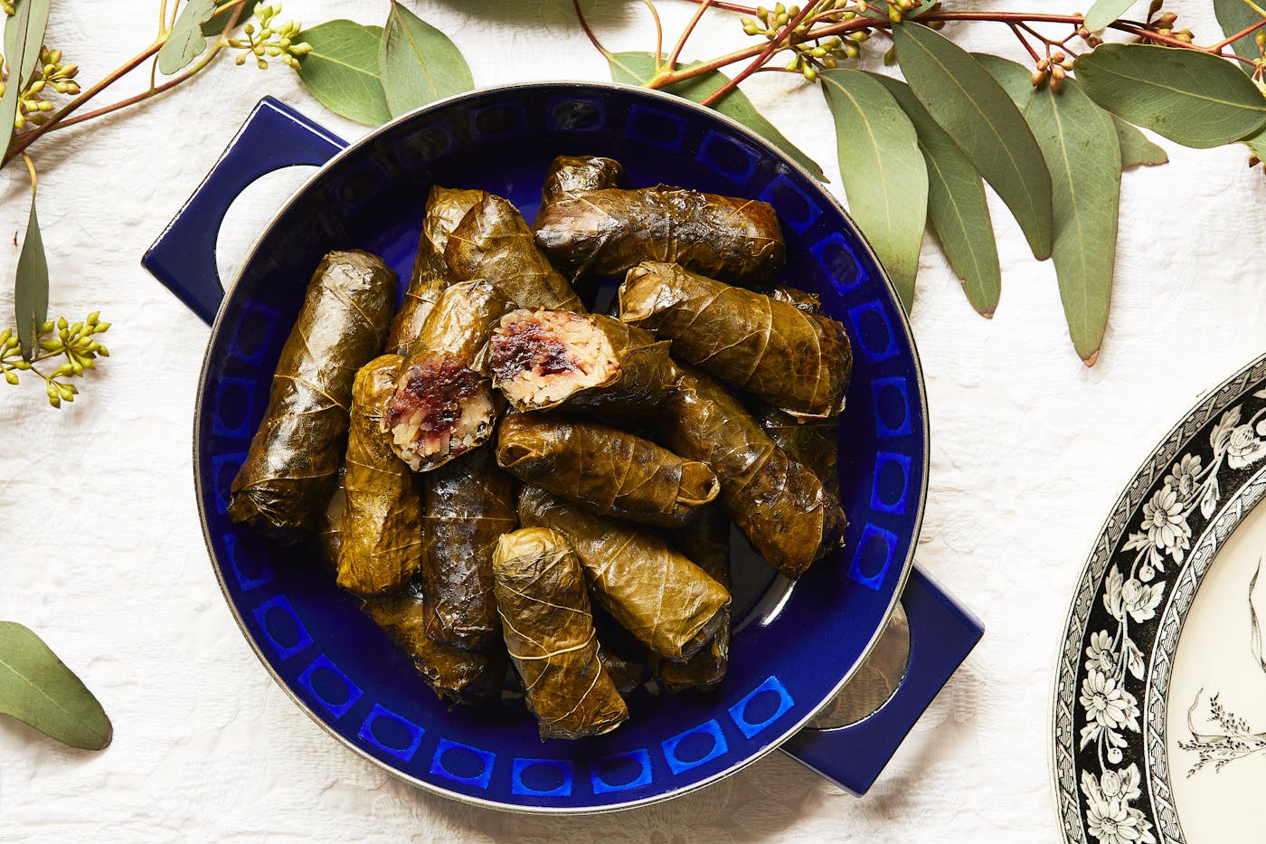 Dolmeh with sweet and sour filling atop a blue platter.