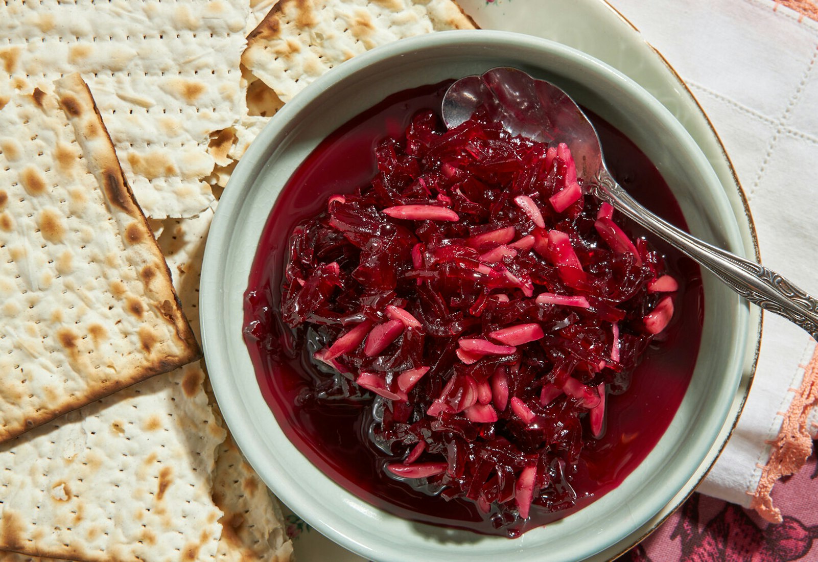 Eingemacht in small bowl with sheets of matzo atop pink and white napkin.