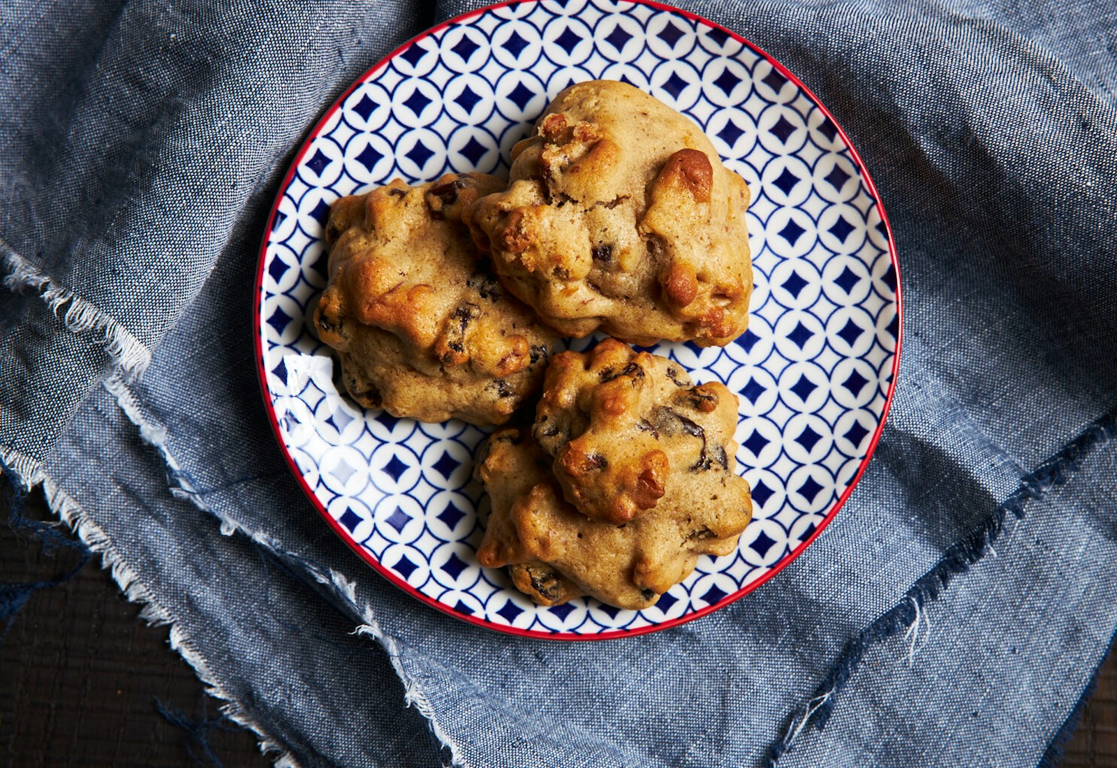 Kermit cookies on black and white dish atop grey cloth.