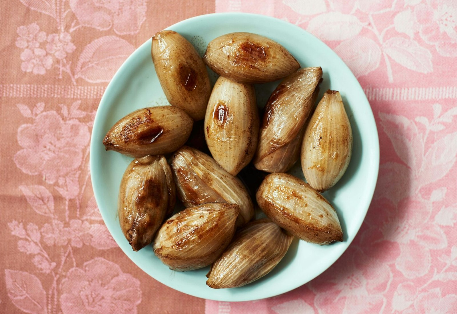 Onion mahshi on blue plate atop pink tablecloth.