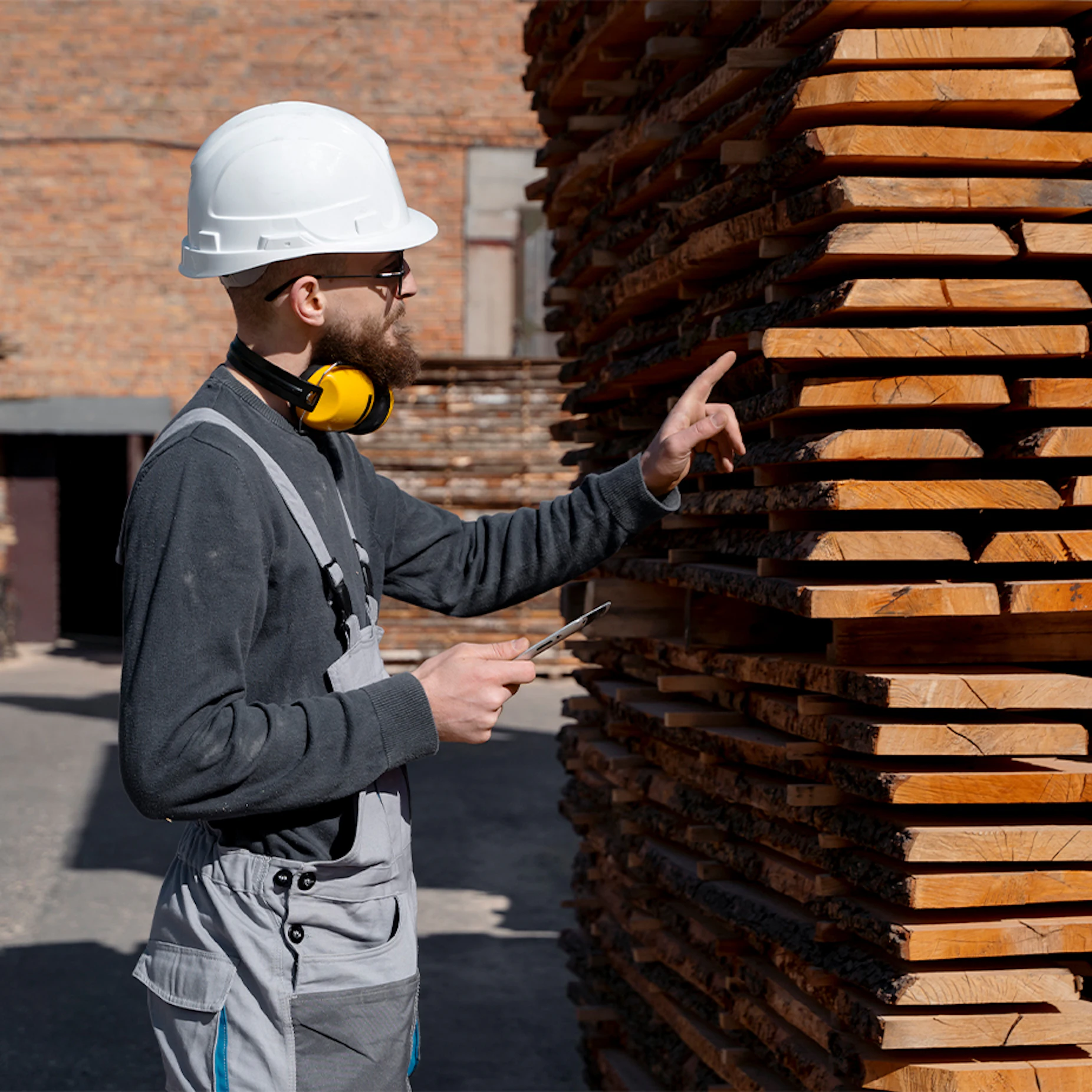 worker counting stacks of manufactured lumber