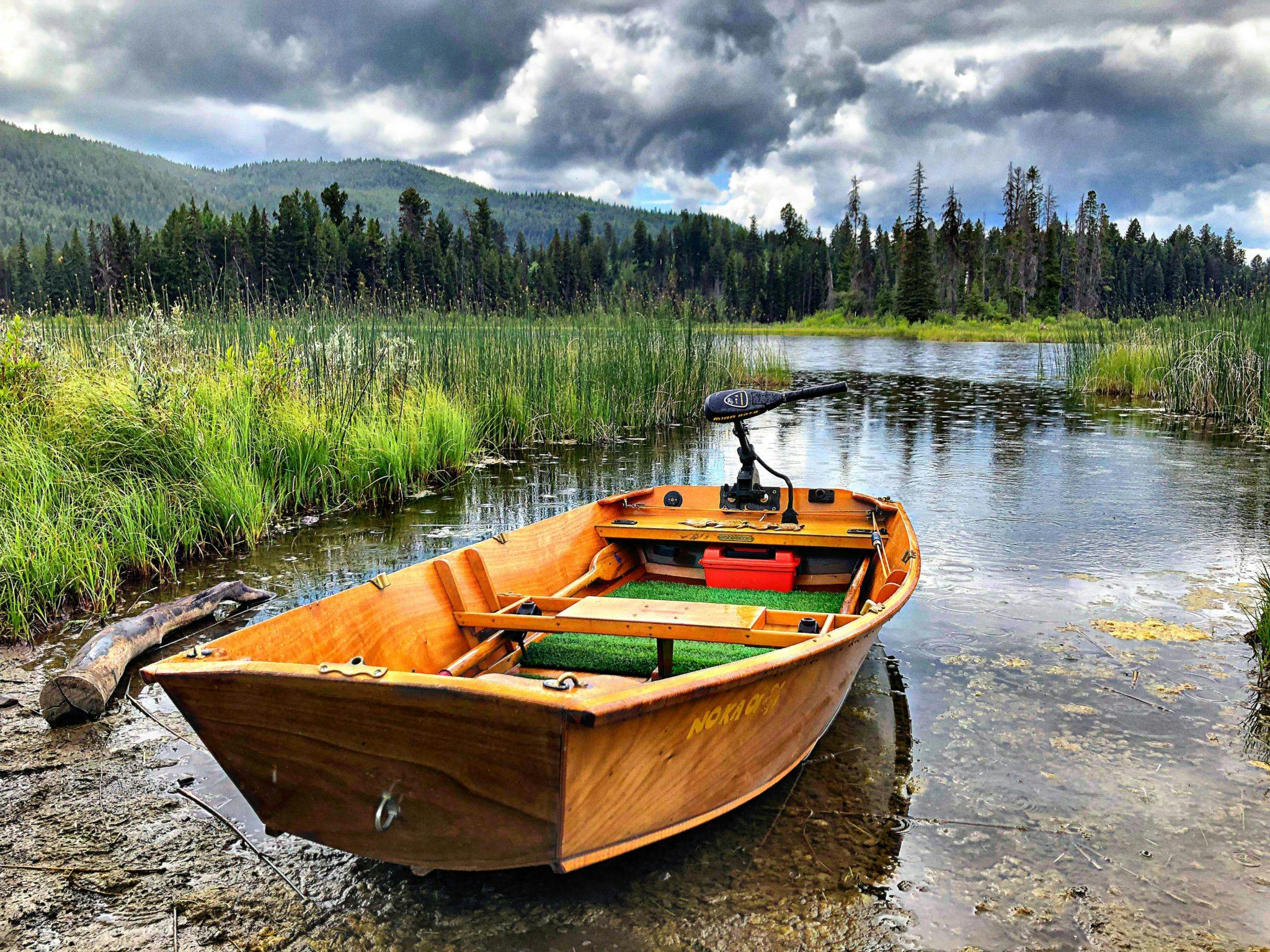 A wooden boat on the side of a lake