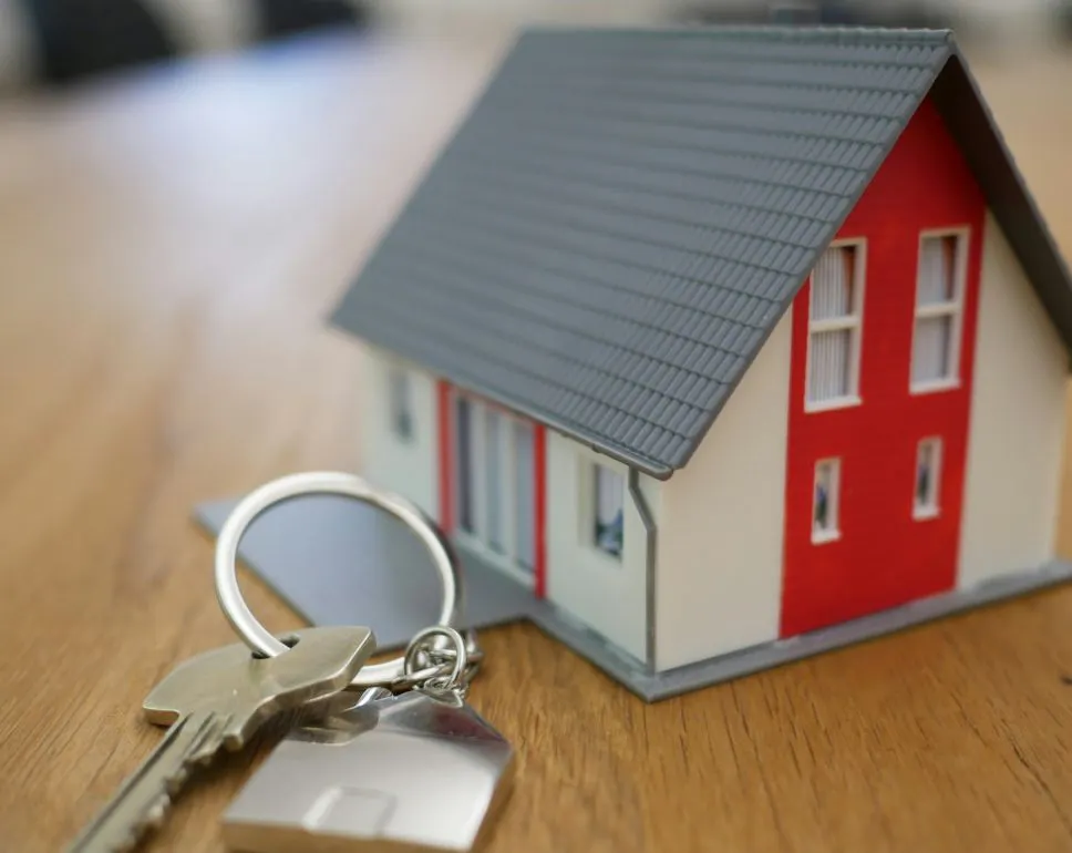 A model of a house with a set of keys laying beside it