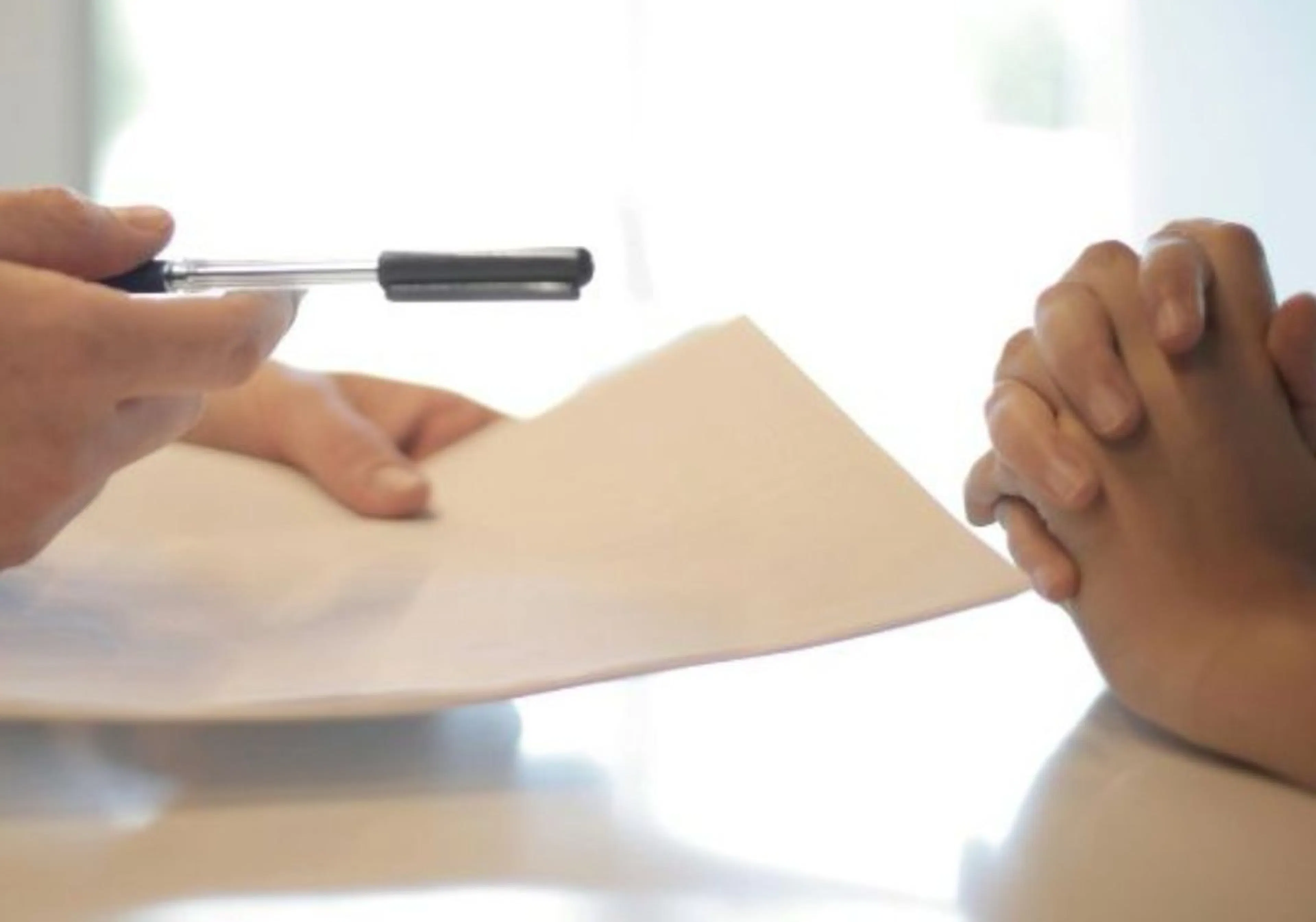 Two people exchanging contract papers