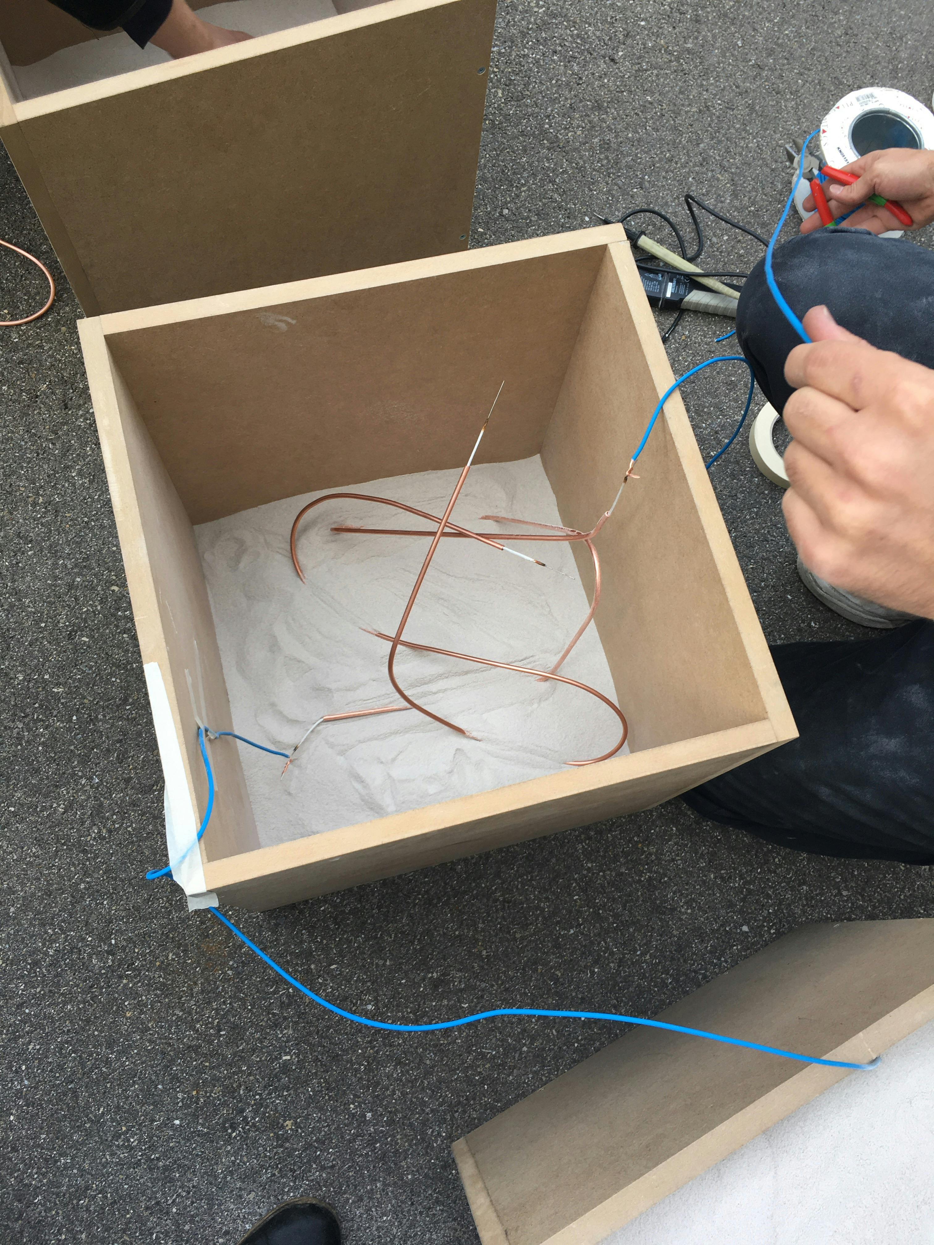 Heating a wire in a box with waste SLS 3-D printing powder