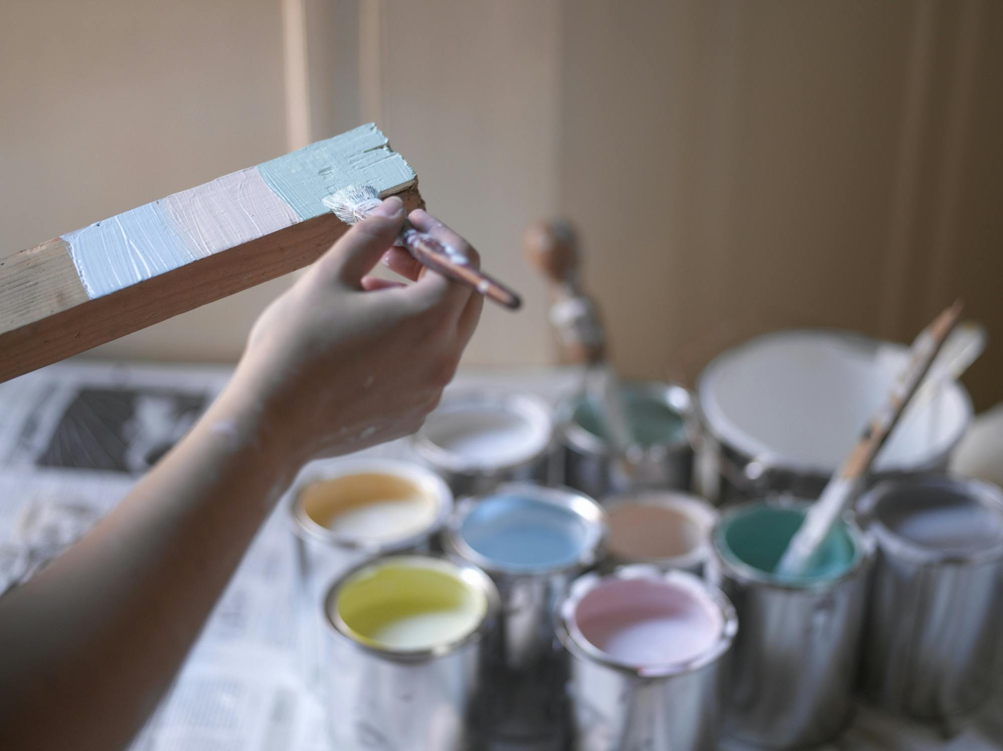 person painting a piece of wood 