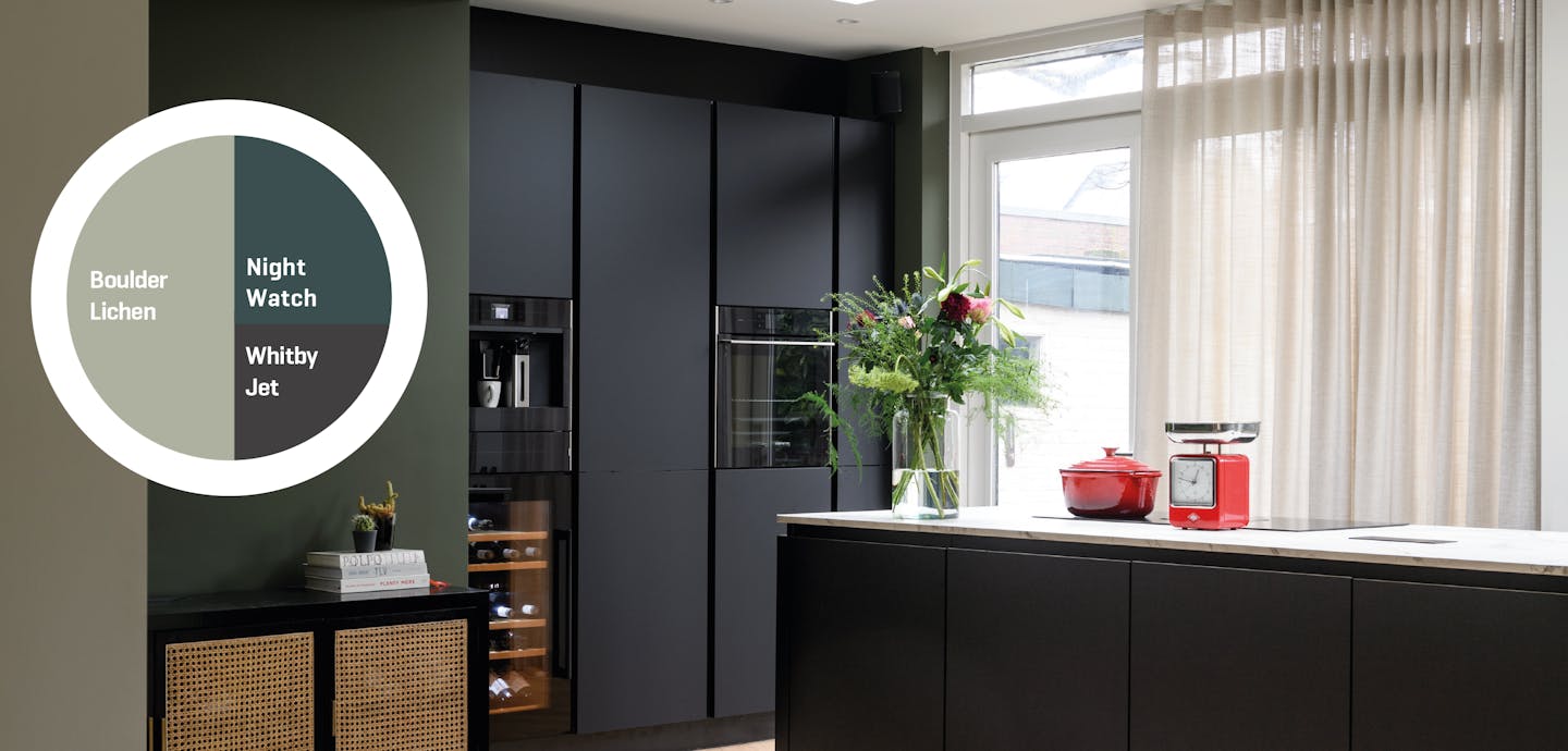 Dark kitchen cabinets with a pale green wall 