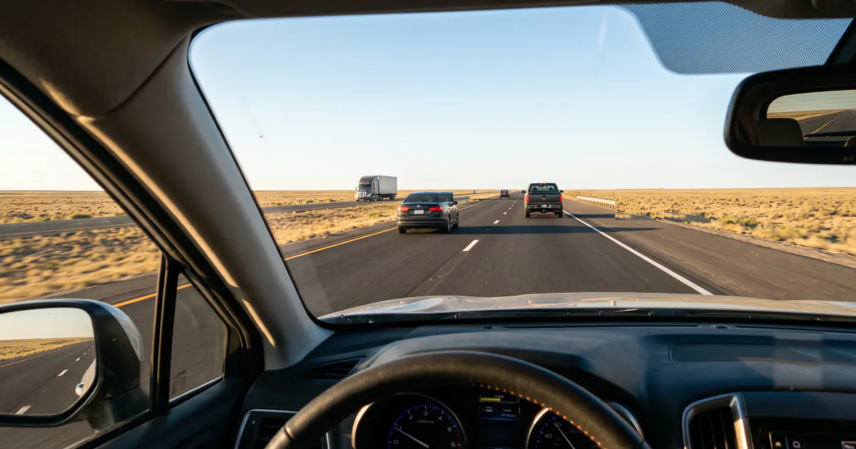 image of someone looking out of their car window while driving down a highway