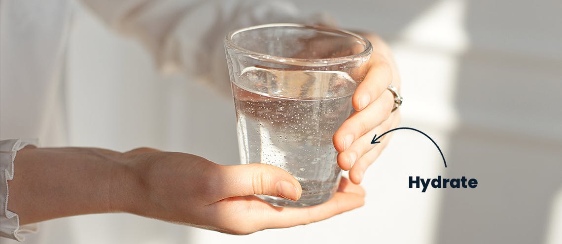 An image of someone holding a glass of water with the word "hydrate" pointing to the glass.