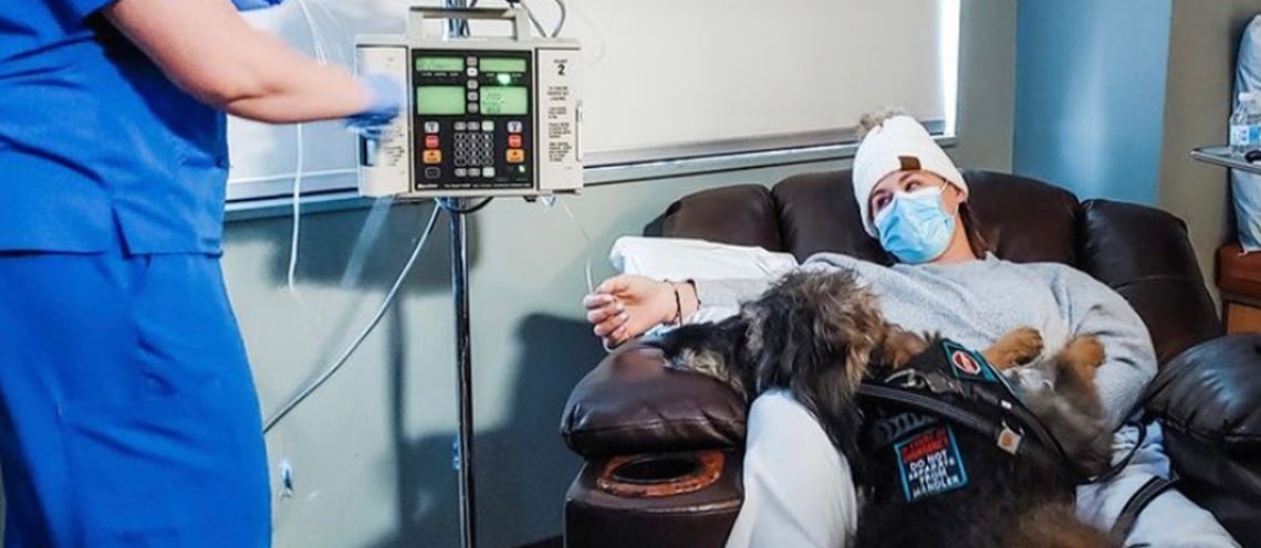 Image of woman in a hospital with a dog in her lap