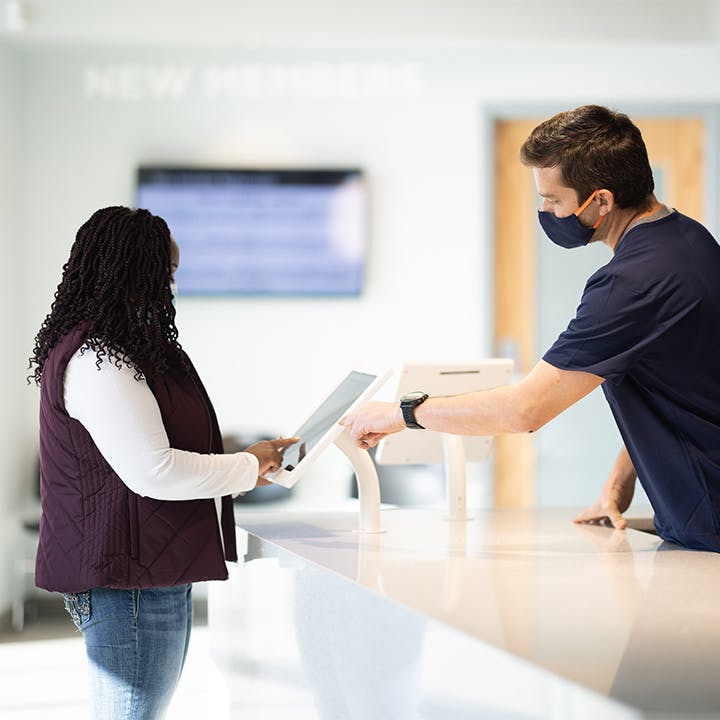 Parachute employee guiding a donor through the checkin process at a center.