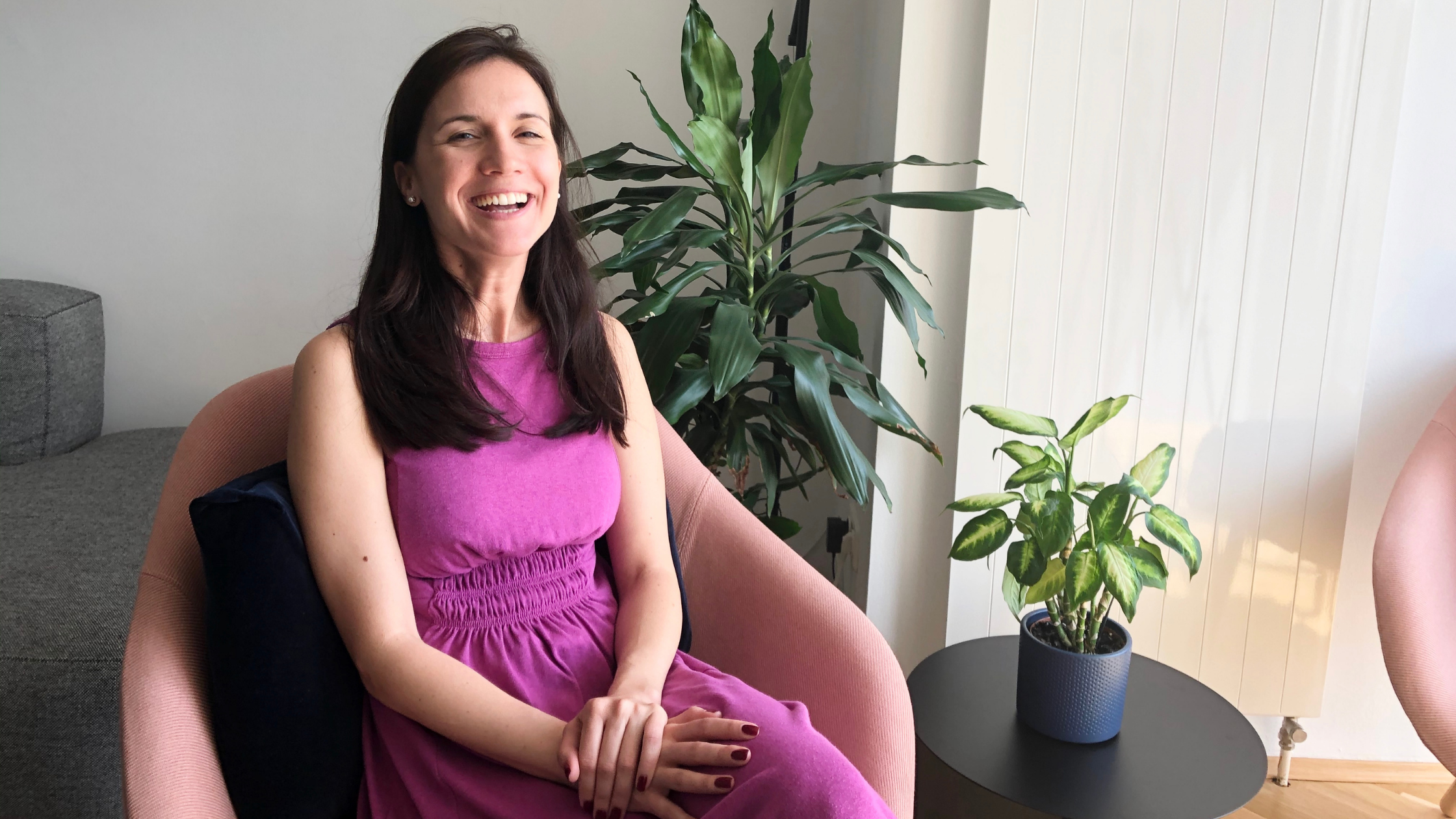 Ivana sitting in a designer chair in a LifeX coliving apartment