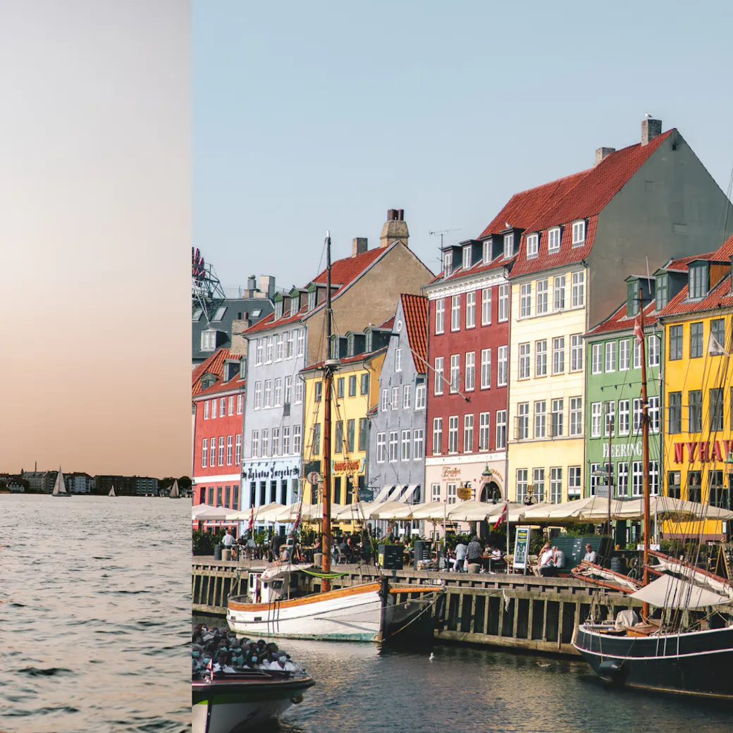 Iconic colorful buildings at Nyhavn and a sailing boat sailing on calm water