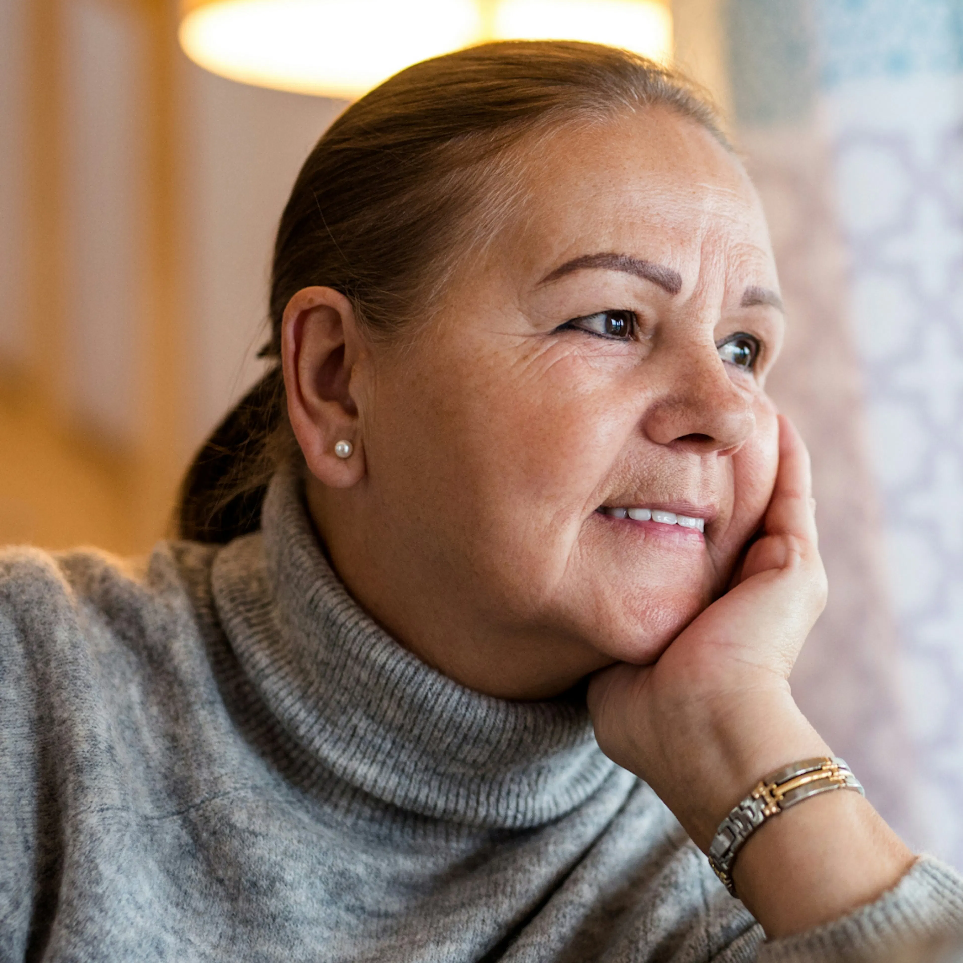 A close-up photo of a woman in menopause with her hand on her face. 
