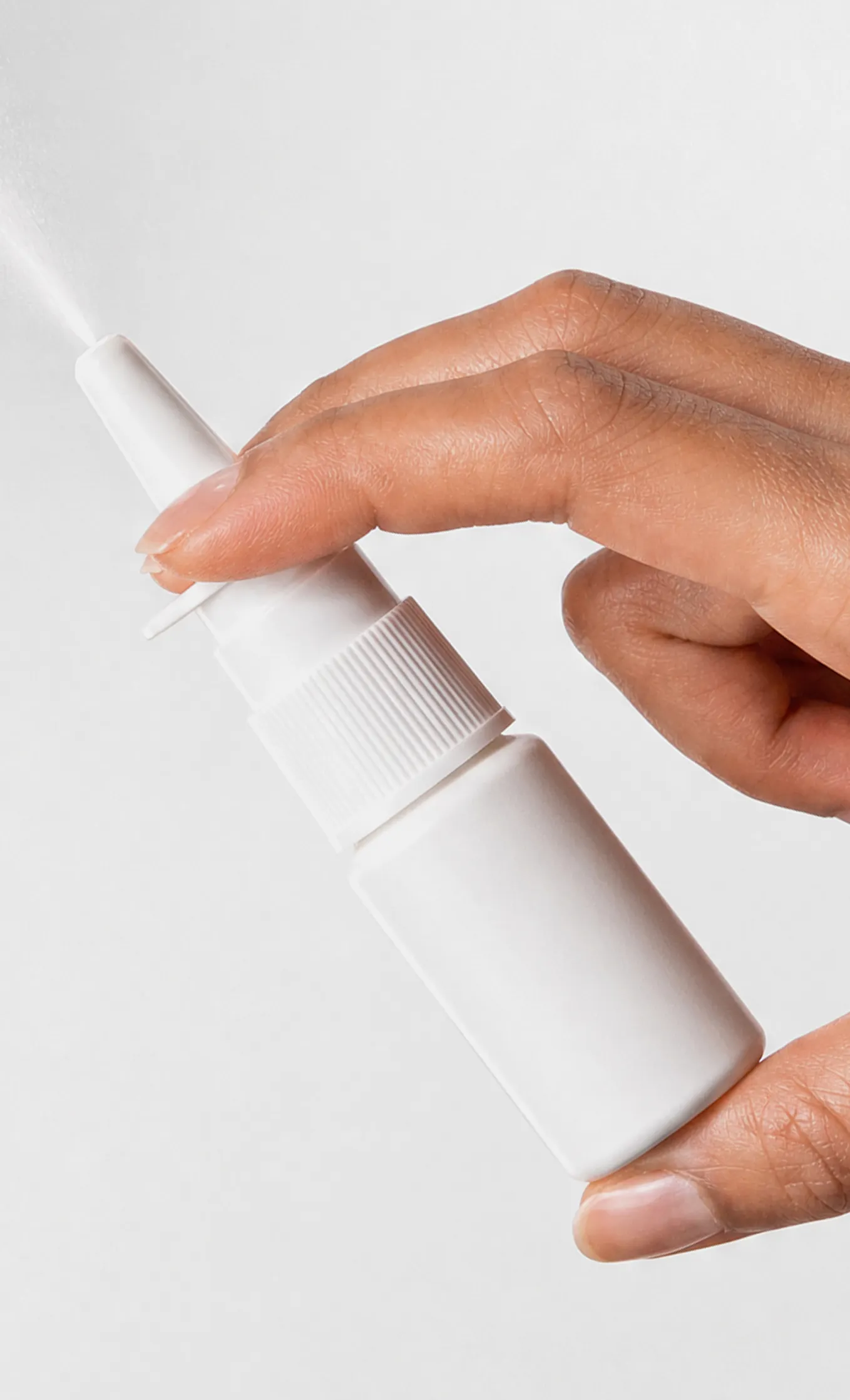 Hand holding a nasal spray bottle