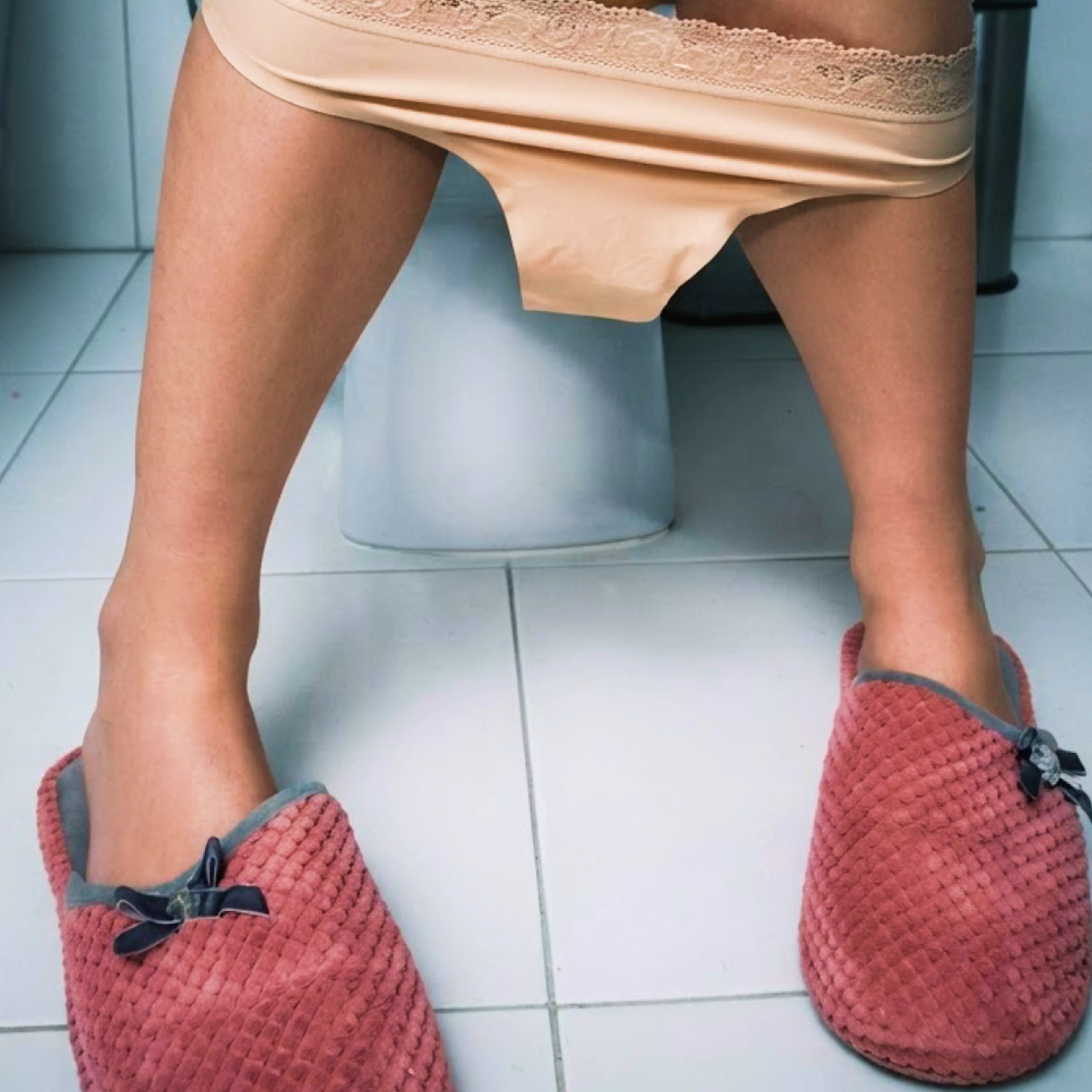 A close-up image of someone's slippers in the bathroom.
