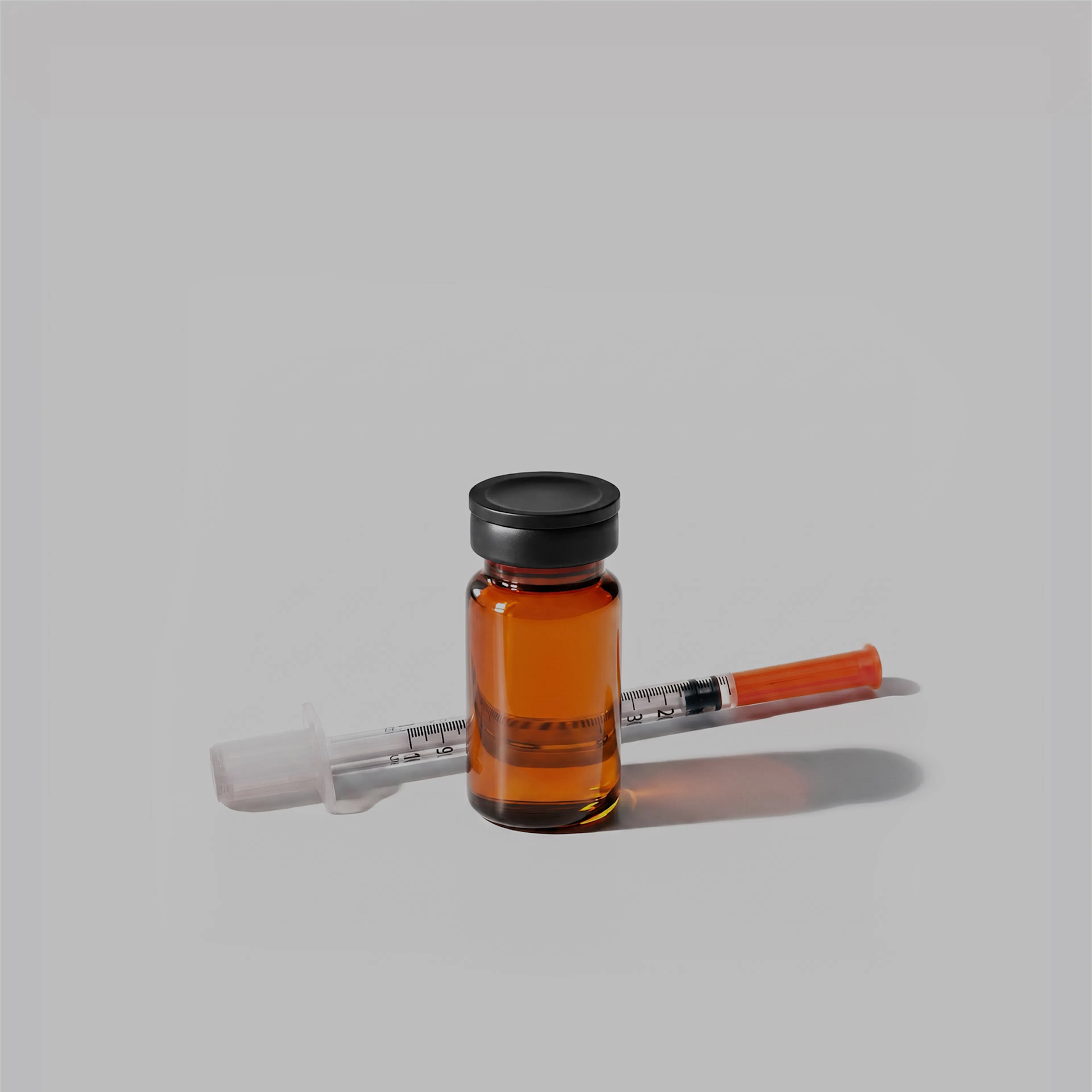 Amber glass vial beside thin syringe