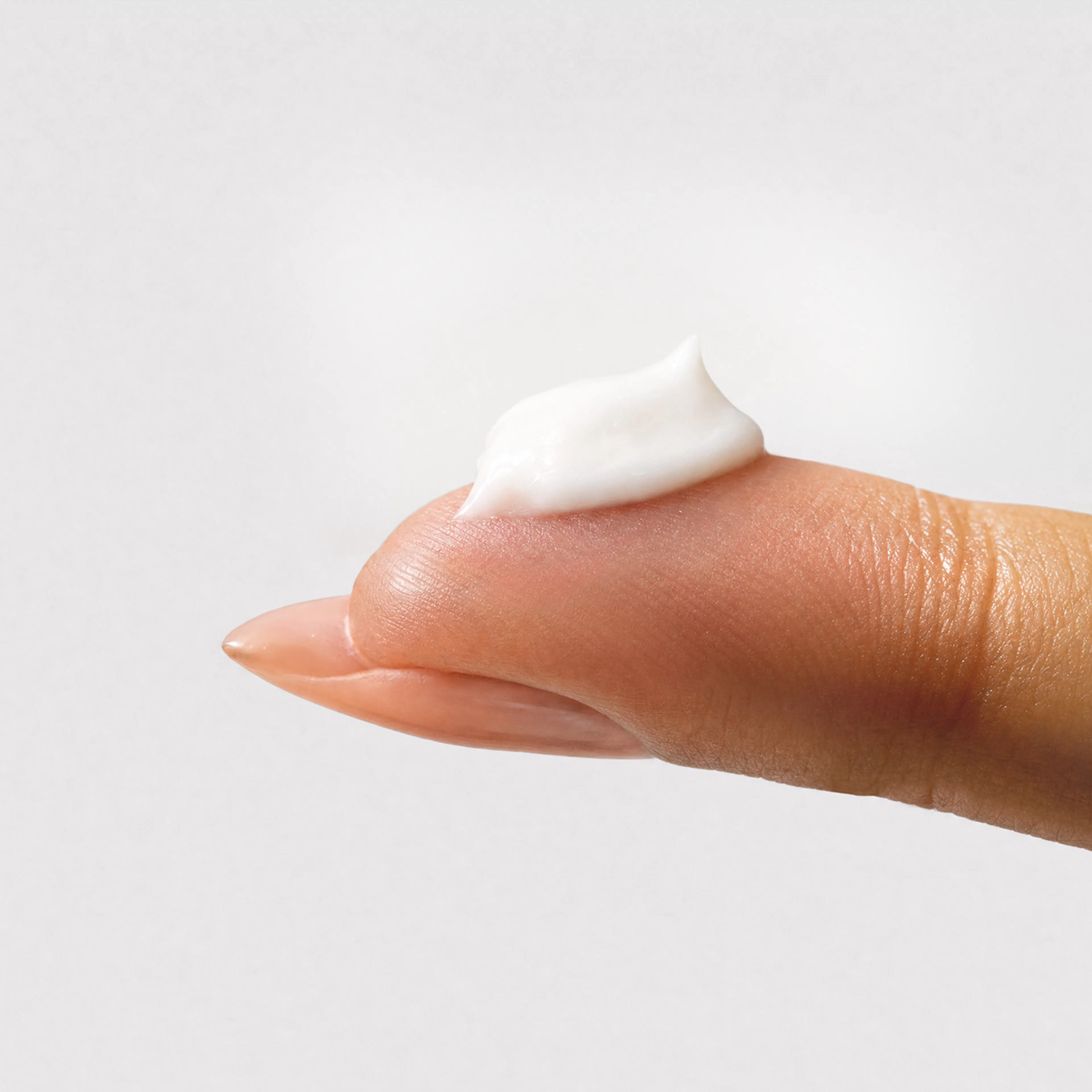 Fingertip holding a dollop of Estriol Face Cream.