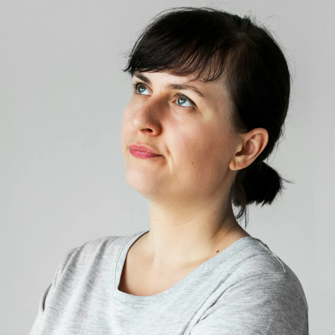 A woman in perimenopause looking up and thinking. She is wondering why she is experiencing perimenopause spotting when wiping.