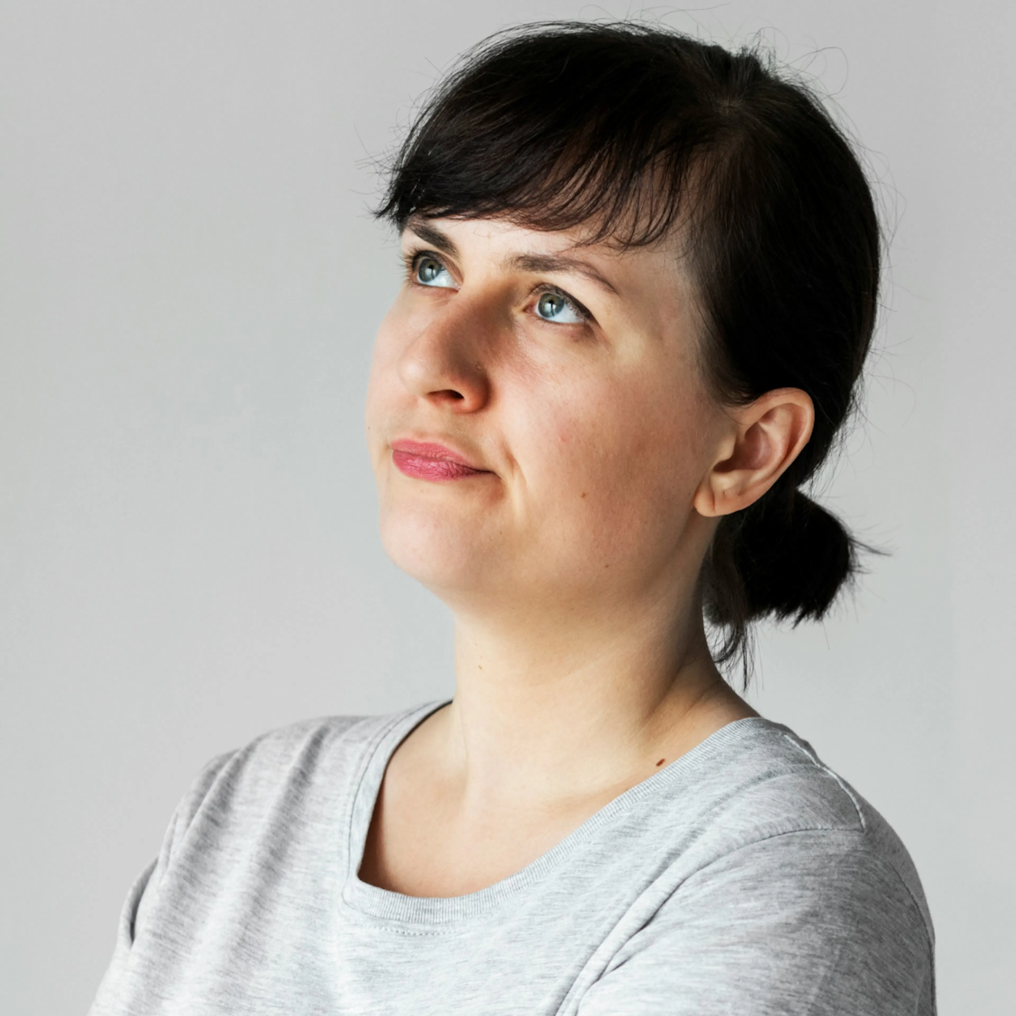 A woman in perimenopause looking up and thinking. She is wondering why she is experiencing perimenopause spotting when wiping.