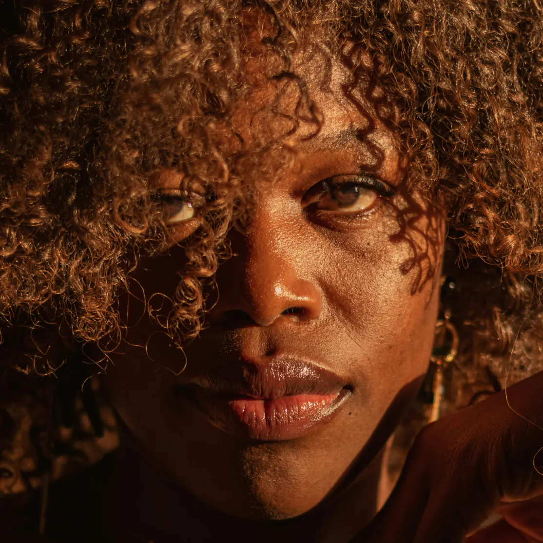 A close-up photo of a woman's face with glowing skin.