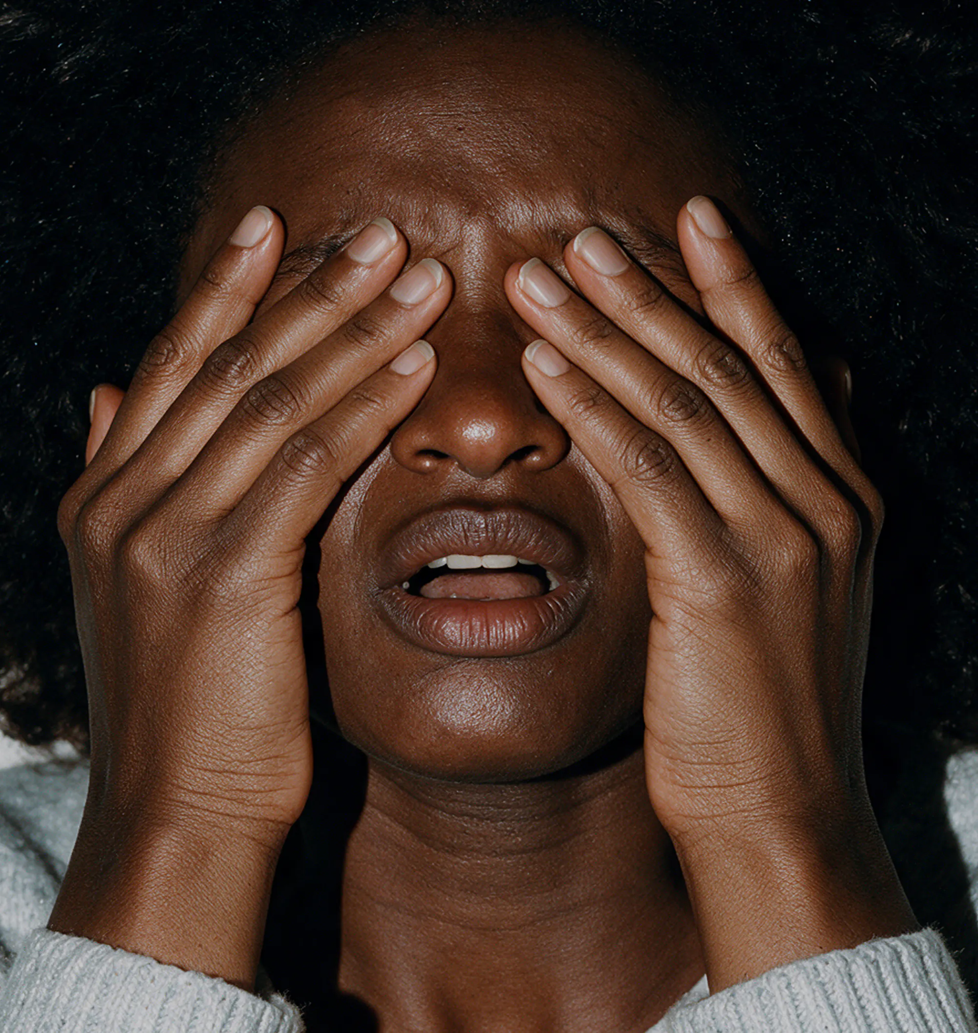 Person covering their eyes with their hands while experiencing brain fog and mental fatigue.