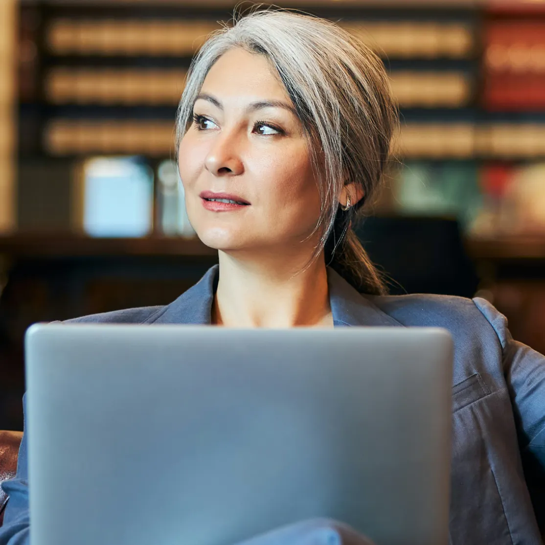 A woman in midlife on a computer, wondering about tirzepatide.