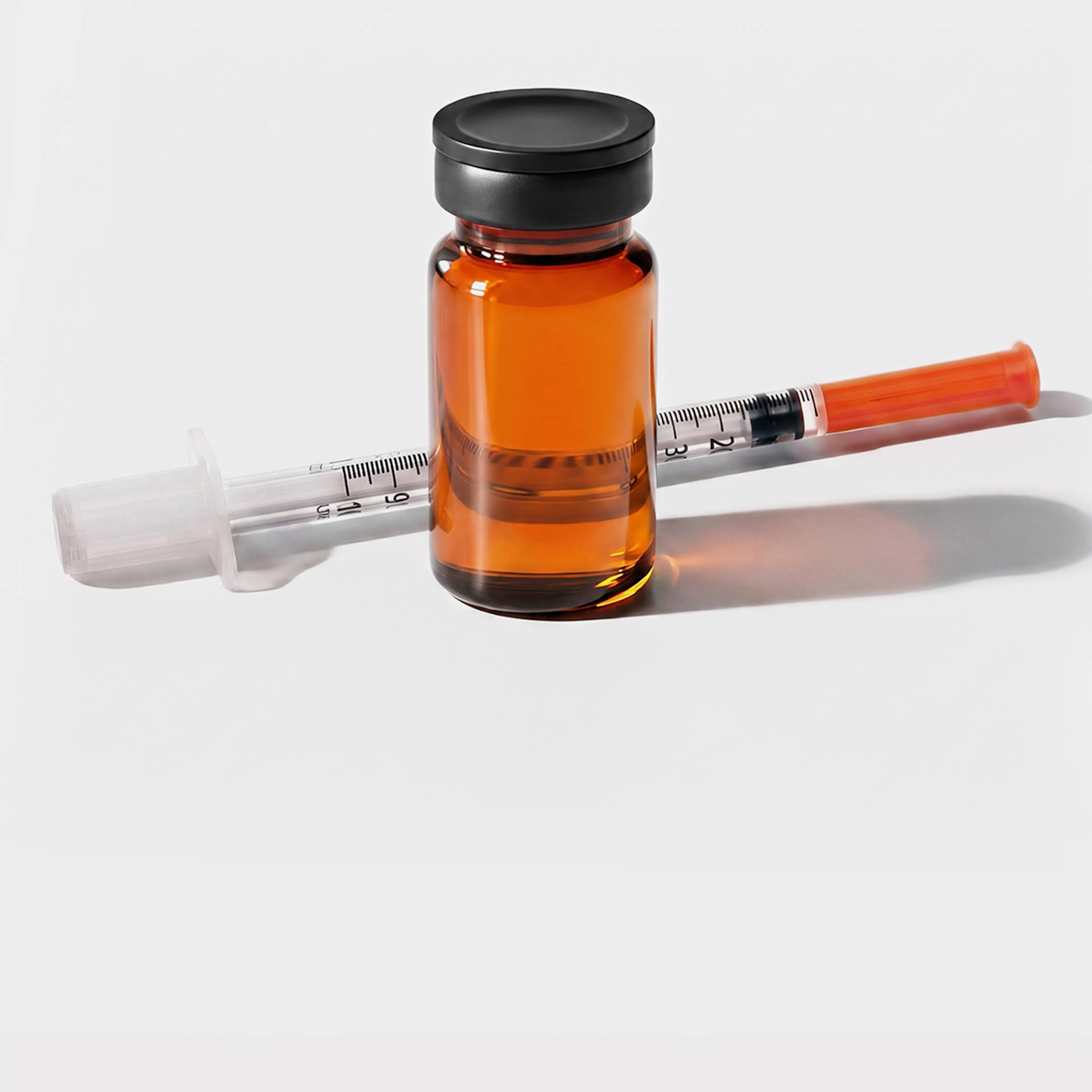 Amber glass vial beside thin syringe.