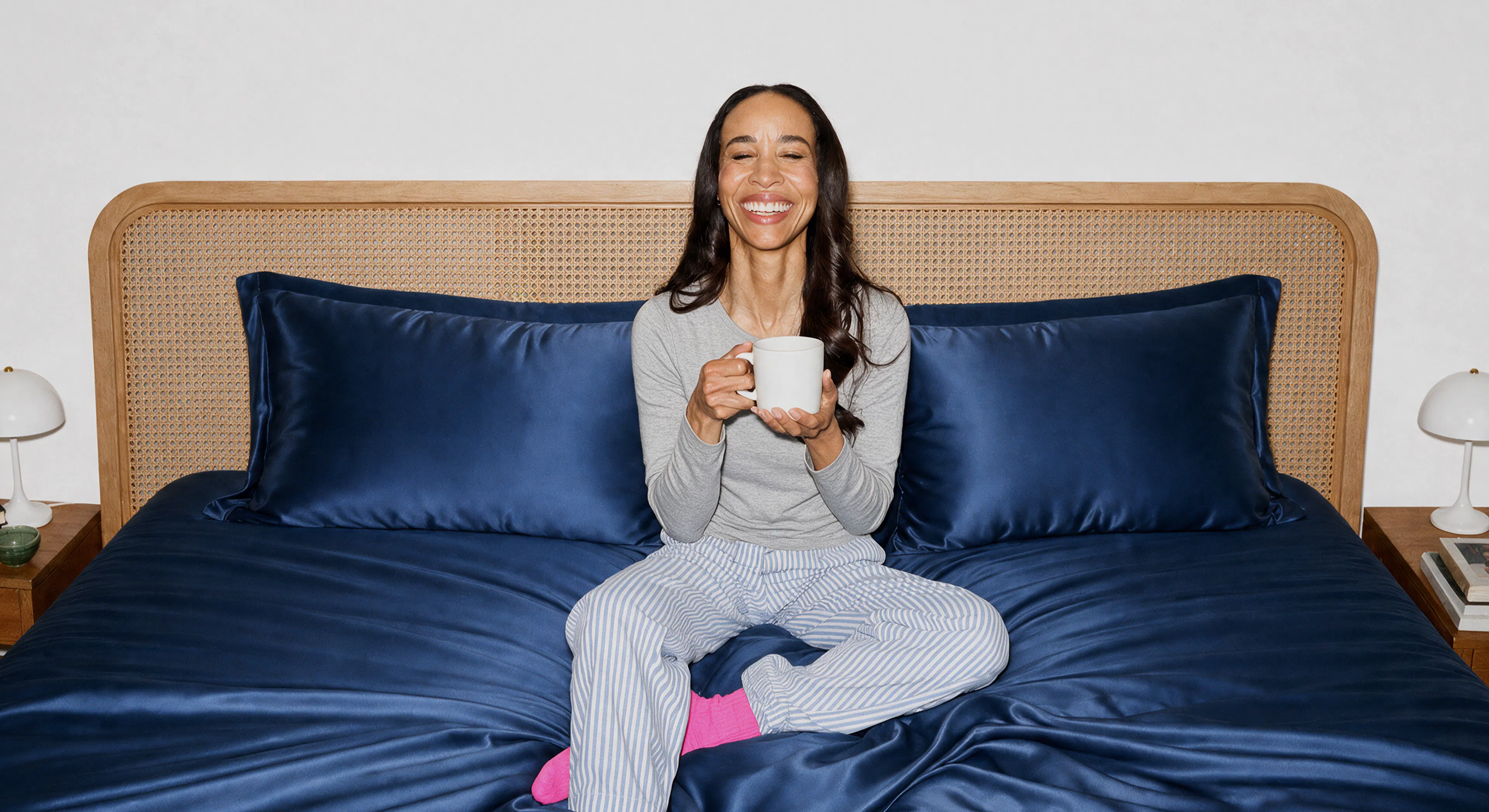 Woman in bed holding coffee mug