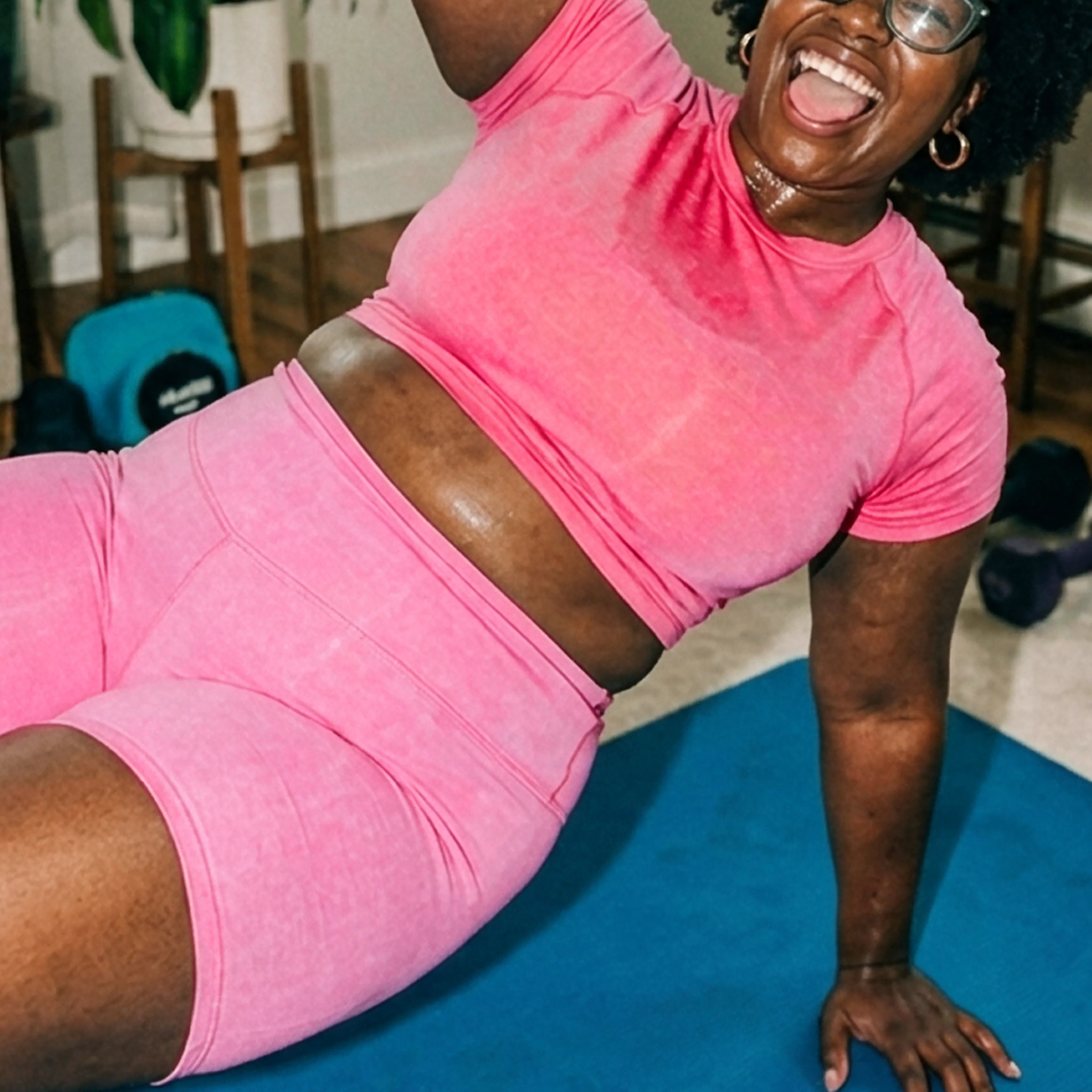Woman lifting dumbbell in side plank