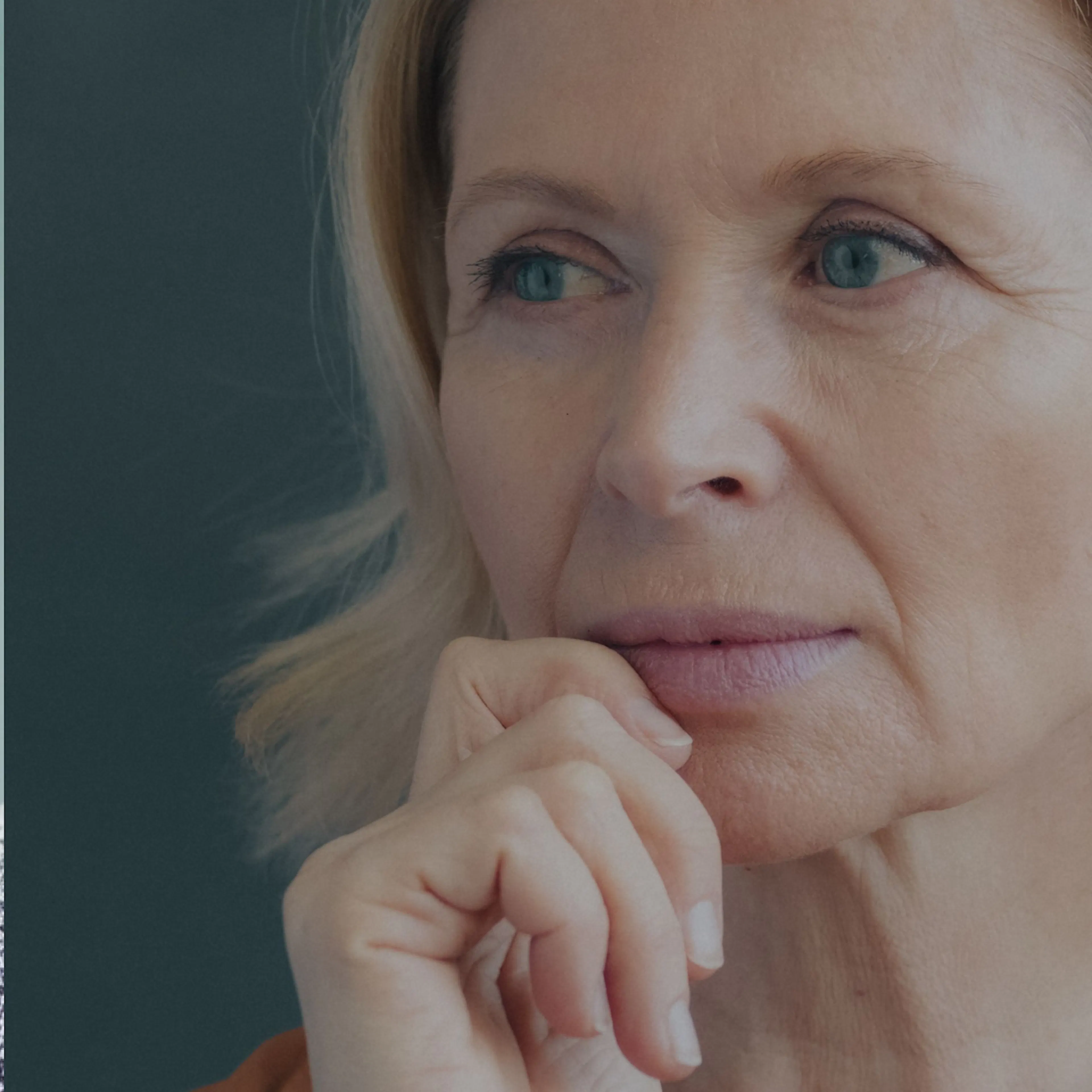 A close-up image of a woman in midlife, looking contemplative.