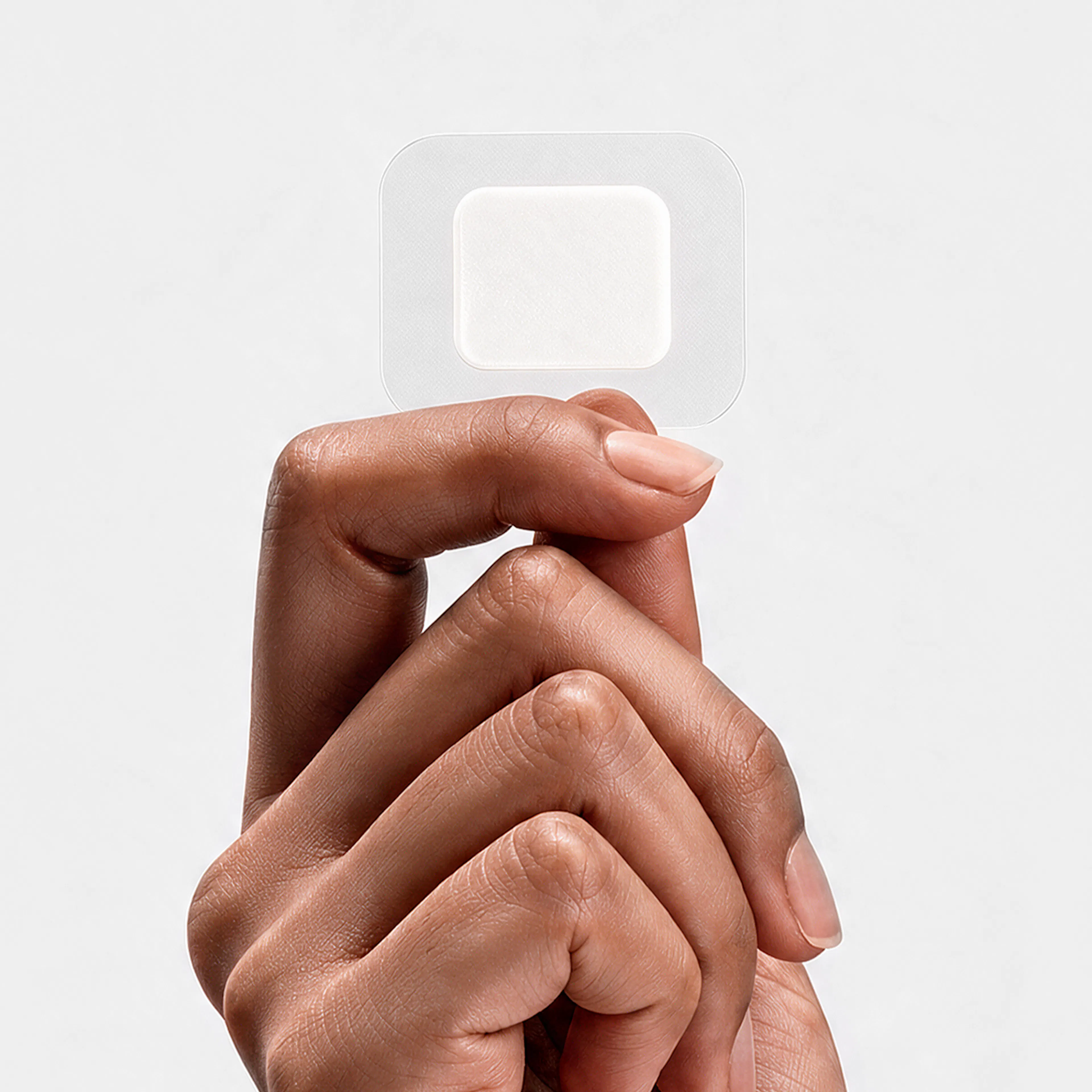 hand holding translucent HRT patch