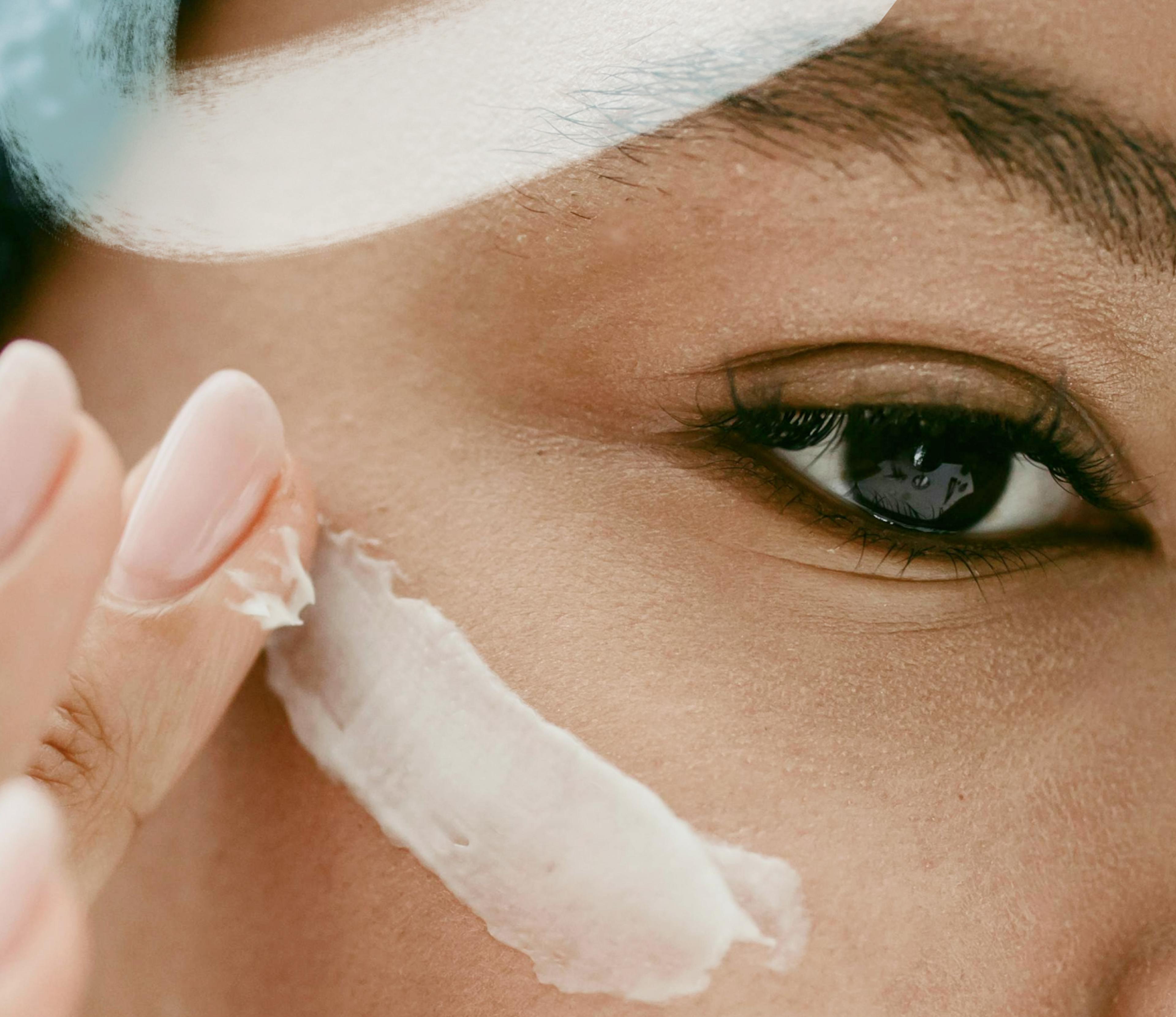 image of a woman swiping cream on her cheek