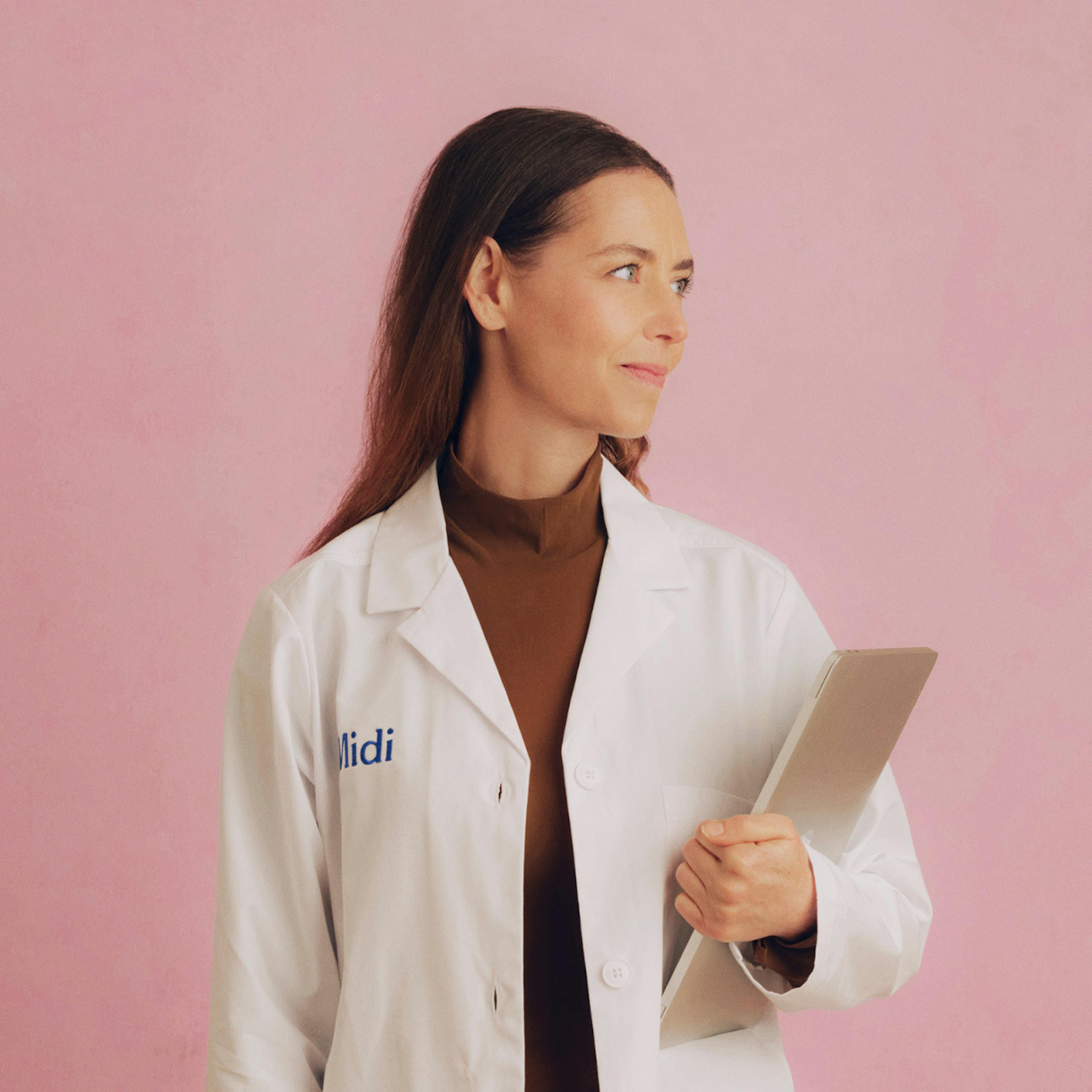 Photograph of Midi clinician holding a clipboard, looking to the side