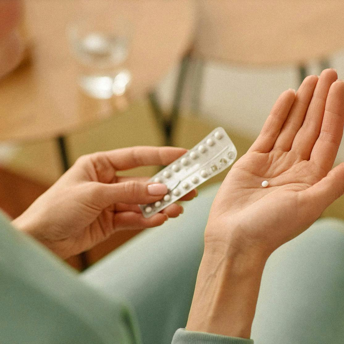 Image of woman holding birth control pill pack in hands