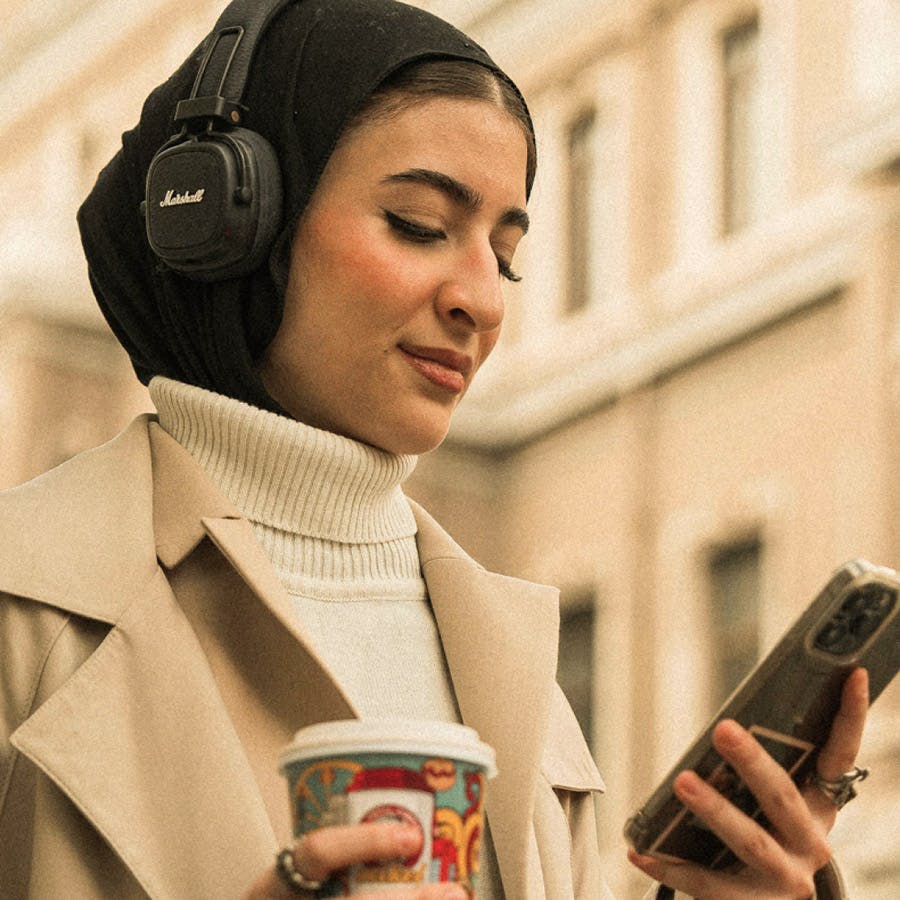 Woman wearing headphones looking at device