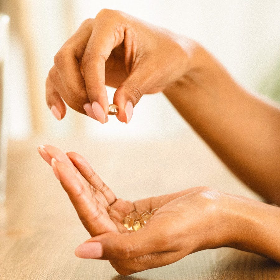 Photo of a person's hands with vitamins in them