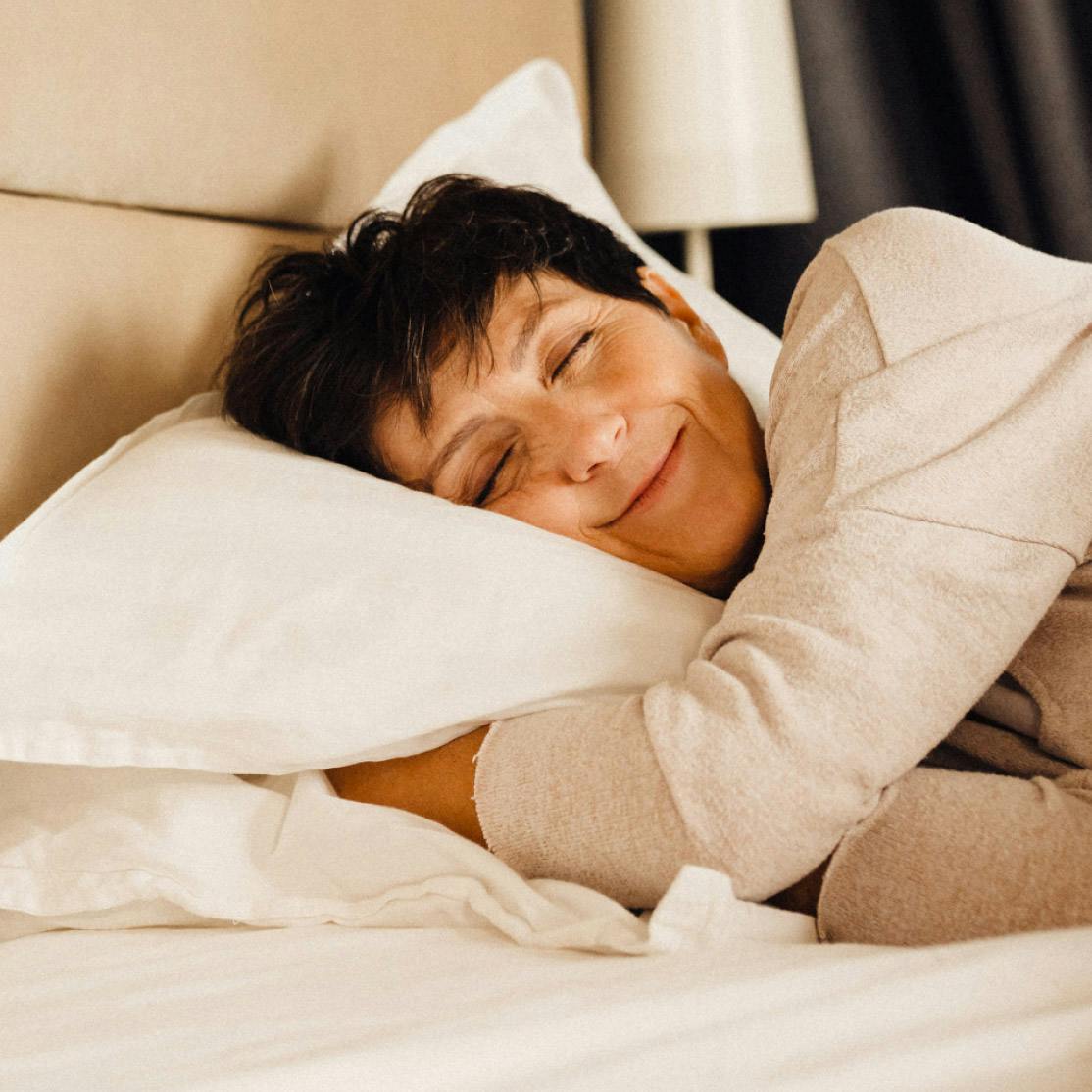 Image of woman lying in bed on her side