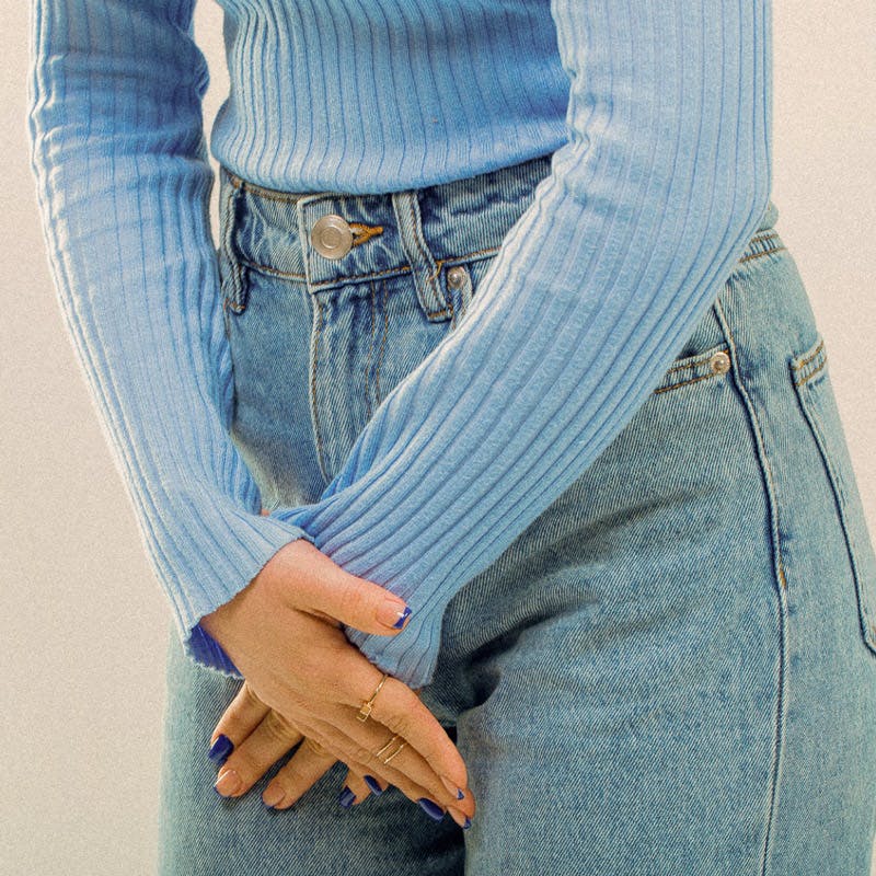 Image of woman holding hands in front of crotch