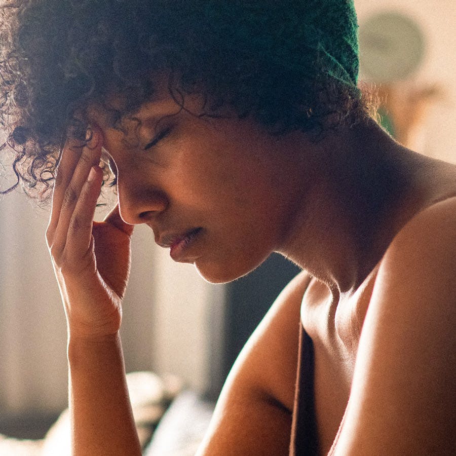 woman with her eyes closed and hand on forehead