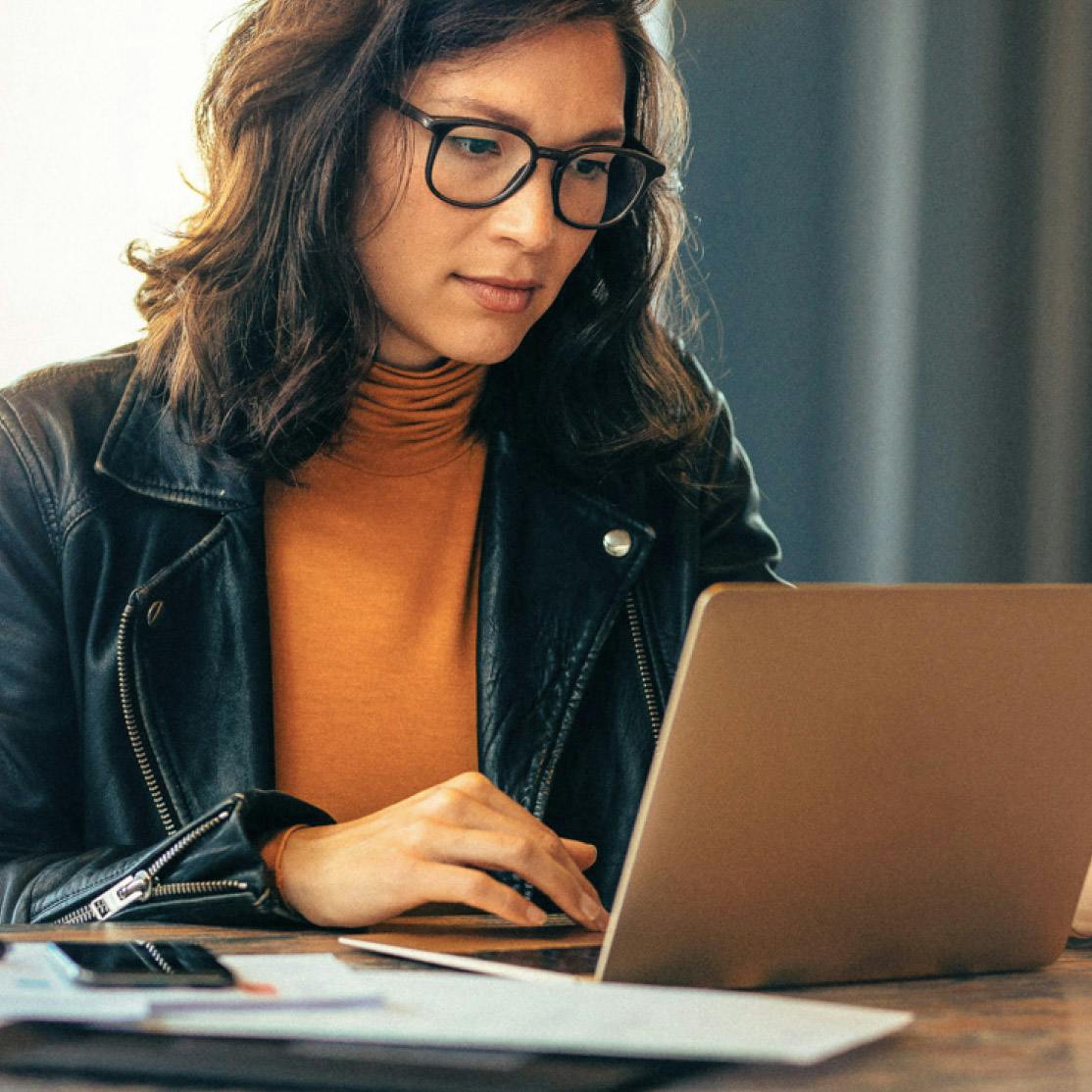 Woman at a desk looking at her laptop