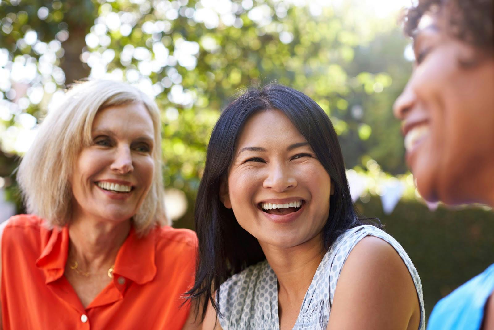 Three women sitting together laughing