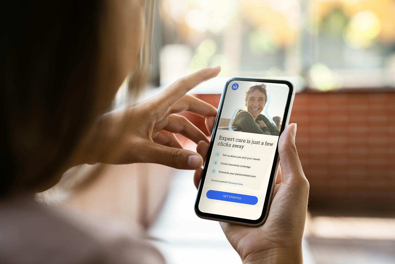 Woman on her phone signing up for a Midi Health Visit