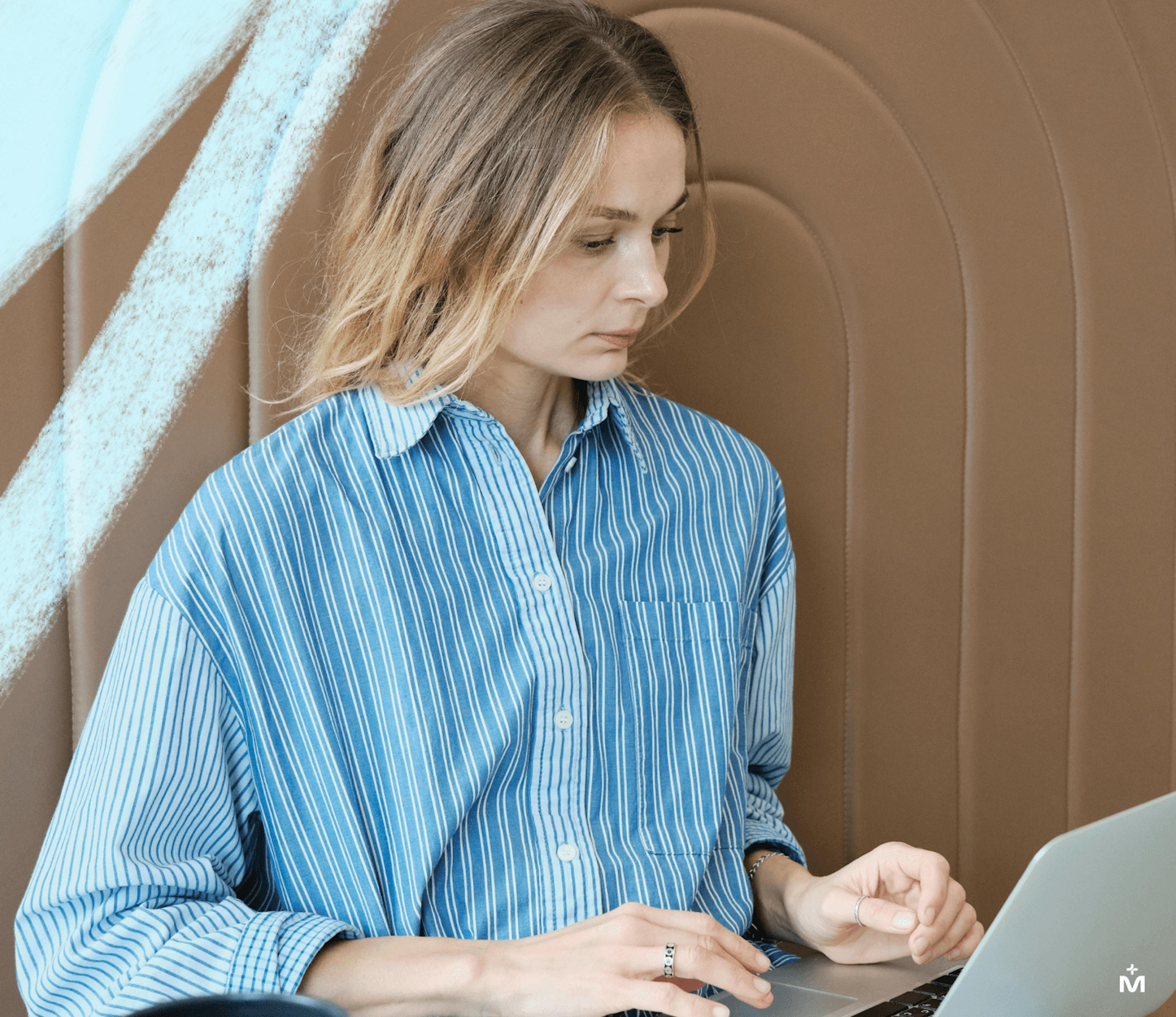 Woman in a blue shirt looking at a computer