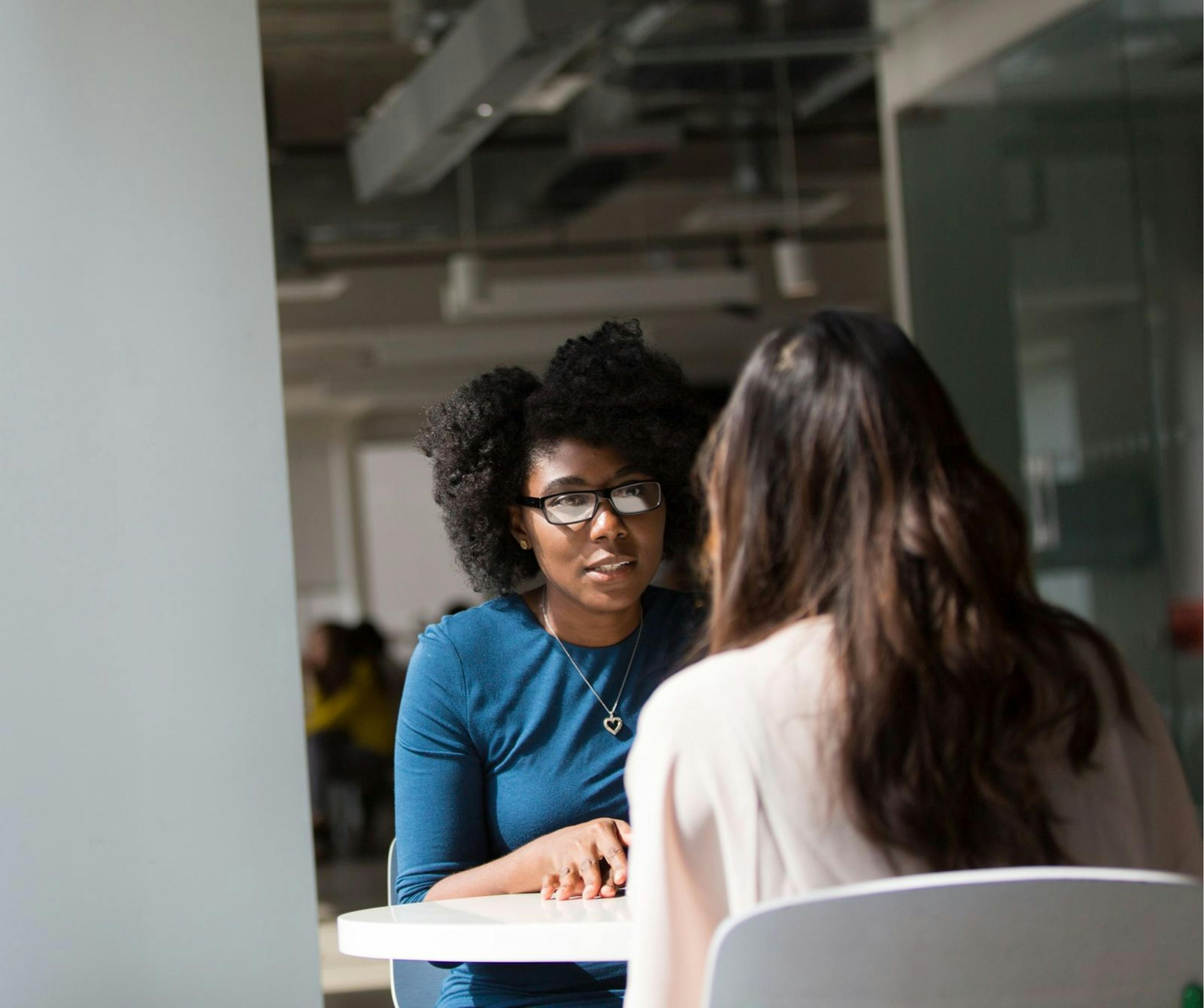 Two women sitting at a table and talking