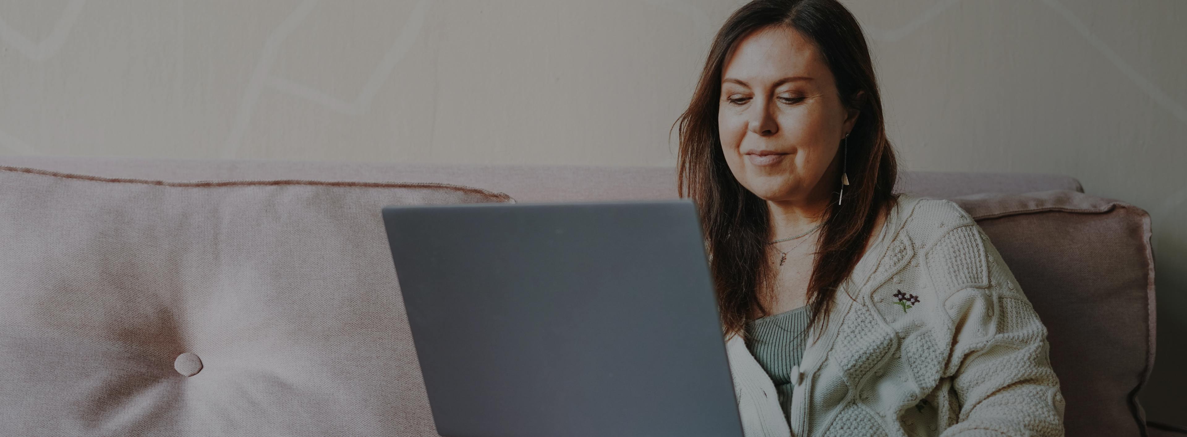 woman on a couch looking at computer